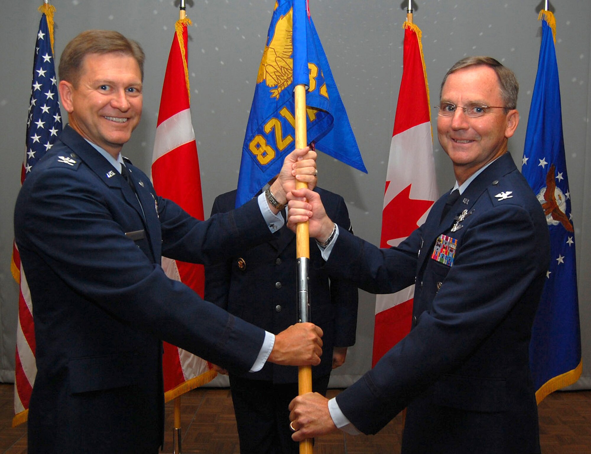 Col. Thomas Peppard (right) receives the 821st Air Base Group guidon from Col. Wayne Monteith, 21st Space Wing vice commander, as he assumes command during the group’s change-of-command ceremony July 17 at the Top of the World Club at Thule Air Base, Greenland. As the installation commander, Colonel Peppard is responsible for the administration and security of the Air Force's largest overseas and America's northernmost base comprised of the Thule Defense Area. As the senior U.S. government representative to Greenland, he guides international relations ensuring compliance of all the agreements between the U.S., Danish and Greenlandic governments. He also directs operations of the world's northernmost deep seaport and the Arctic's largest airfield, and provides full-spectrum base support for about 800 year-round residents. (U.S. Air Force photo/2nd Lt. Drew Paras) 