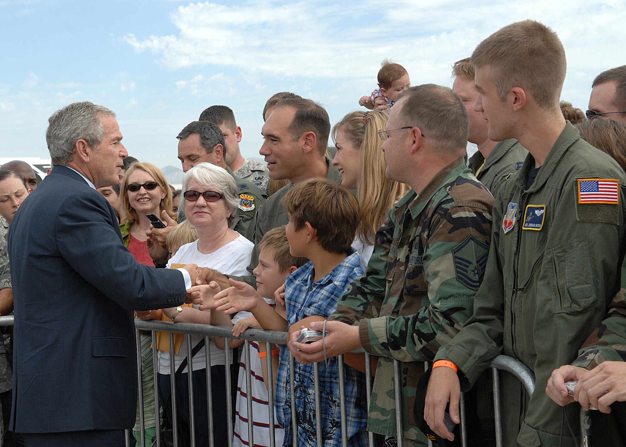 President George W. Bush greets Davis-Monthan Air Force Base Airmen and their families July 18 before departing after a short trip to Tucson, Ariz.  More than 100 members of the D-M team gathered at Base Ops to shake hands and take photos with the president.  (U.S. Air Force photo by Senior Airman Alesia Goosic)