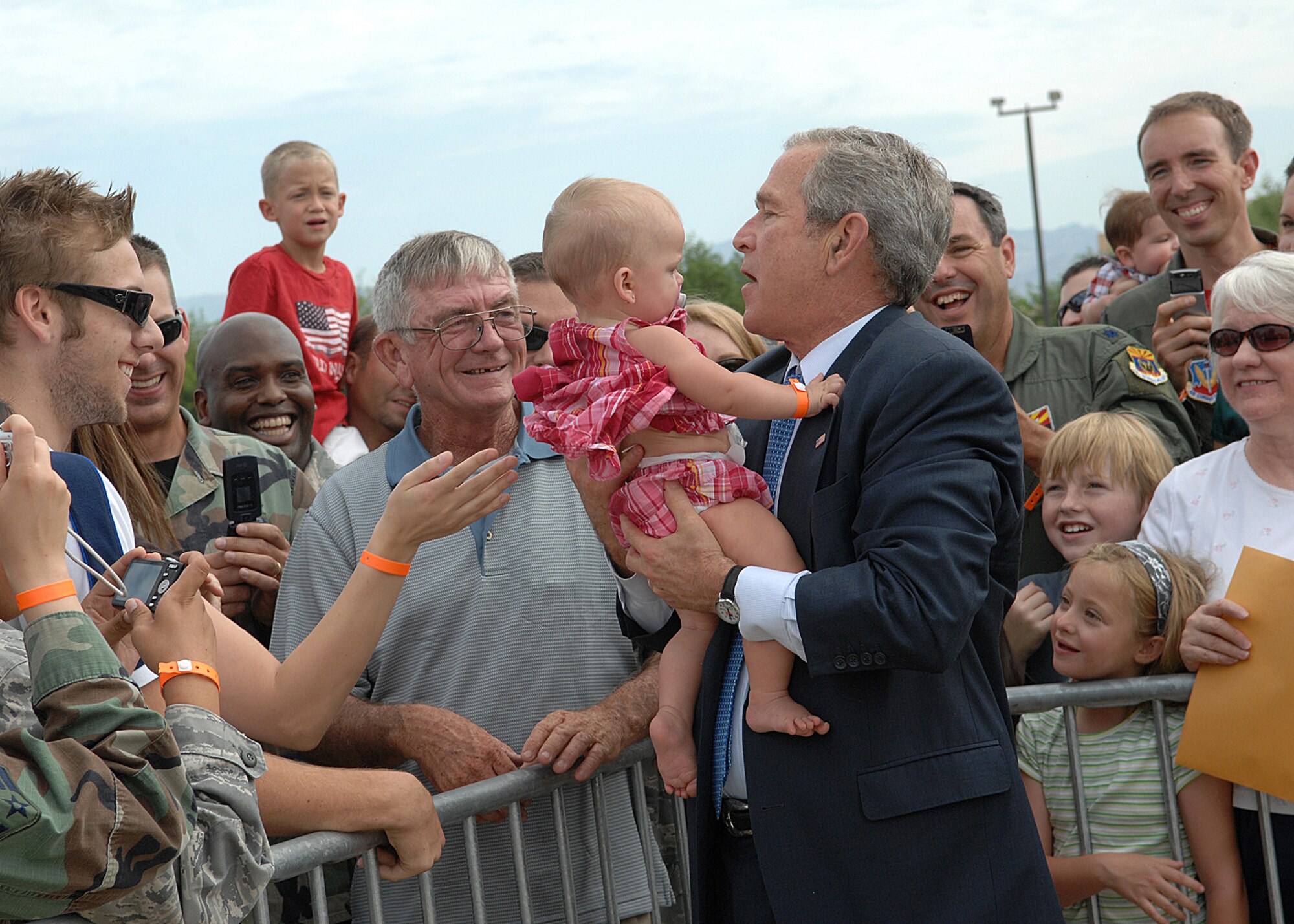 President George W. Bush greets Davis-Monthan Air Force Base Airmen and their families July 18 before departing after a short trip to Tucson, Ariz.  More than 100 members of the D-M team gathered at Base Ops to shake hands and take photos with the president.  (U.S. Air Force photo by Senior Airman Alesia Goosic)