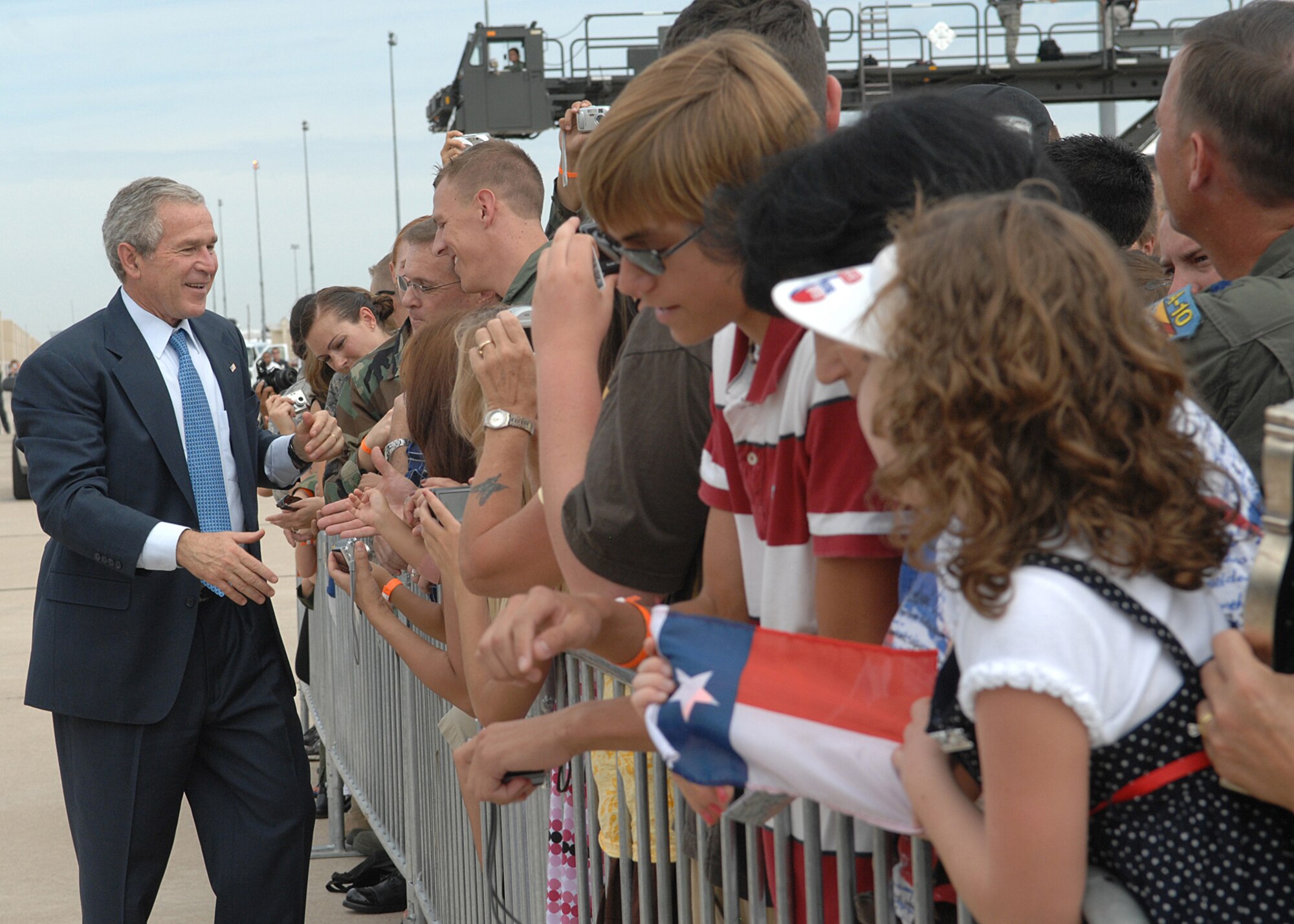 President George W. Bush greets Davis-Monthan Air Force Base Airmen and their families July 18 before departing after a short trip to Tucson, Ariz.  More than 100 members of the D-M team gathered at Base Ops to shake hands and take photos with the president.  (U.S. Air Force photo by Senior Airman Alesia Goosic)