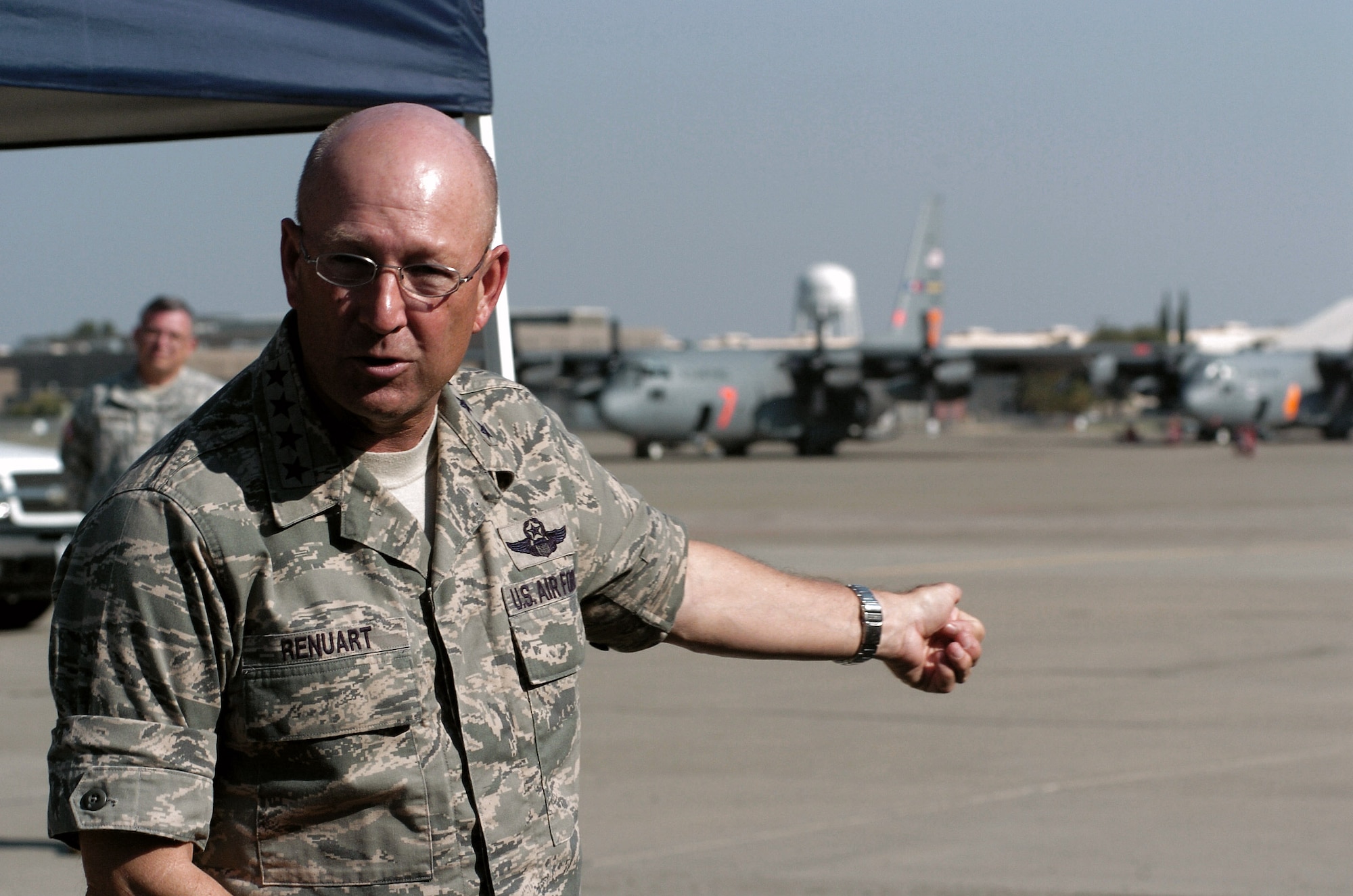Gen. Victor E. Renuart Jr. motions to two of the C-130 Hercules aircraft assigned to the 302nd Air Expeditionary Group during his July 16 visit to McClellan Airfield, Calif. He spoke to Airmen of the 302nd AEG and members of the U.S. Forest Service and California Department of Forestry and Fire Protection, congratulating them all on a job well done in support of California's firefighting operations. General Renuart is the the commander of U.S. Northern Command. (U.S. Air Force photo/Tech. Sgt. Stephen R. Wilkins)