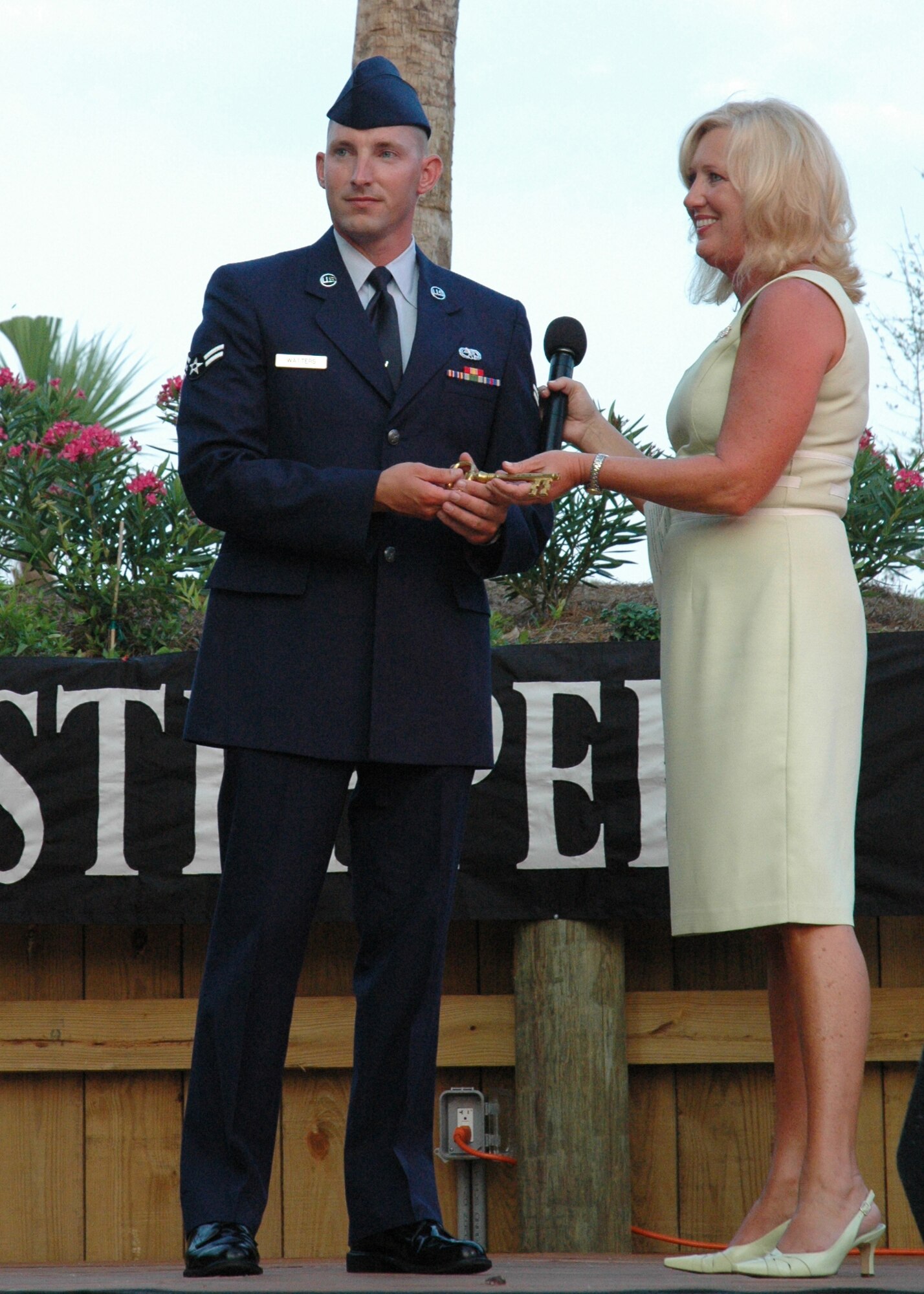 Airman First Class Barry Watters, 33d Maintenance Squadron munitions systems apprentice, smiles at his wife and son after Mayor Pro Temp Sam Seevers presents the key to Destin July 17. He was nominated by his squadron leadership and selected by HarborWalk Village to be the recognized military member at weekly summer Red, White and Blue celebration. 