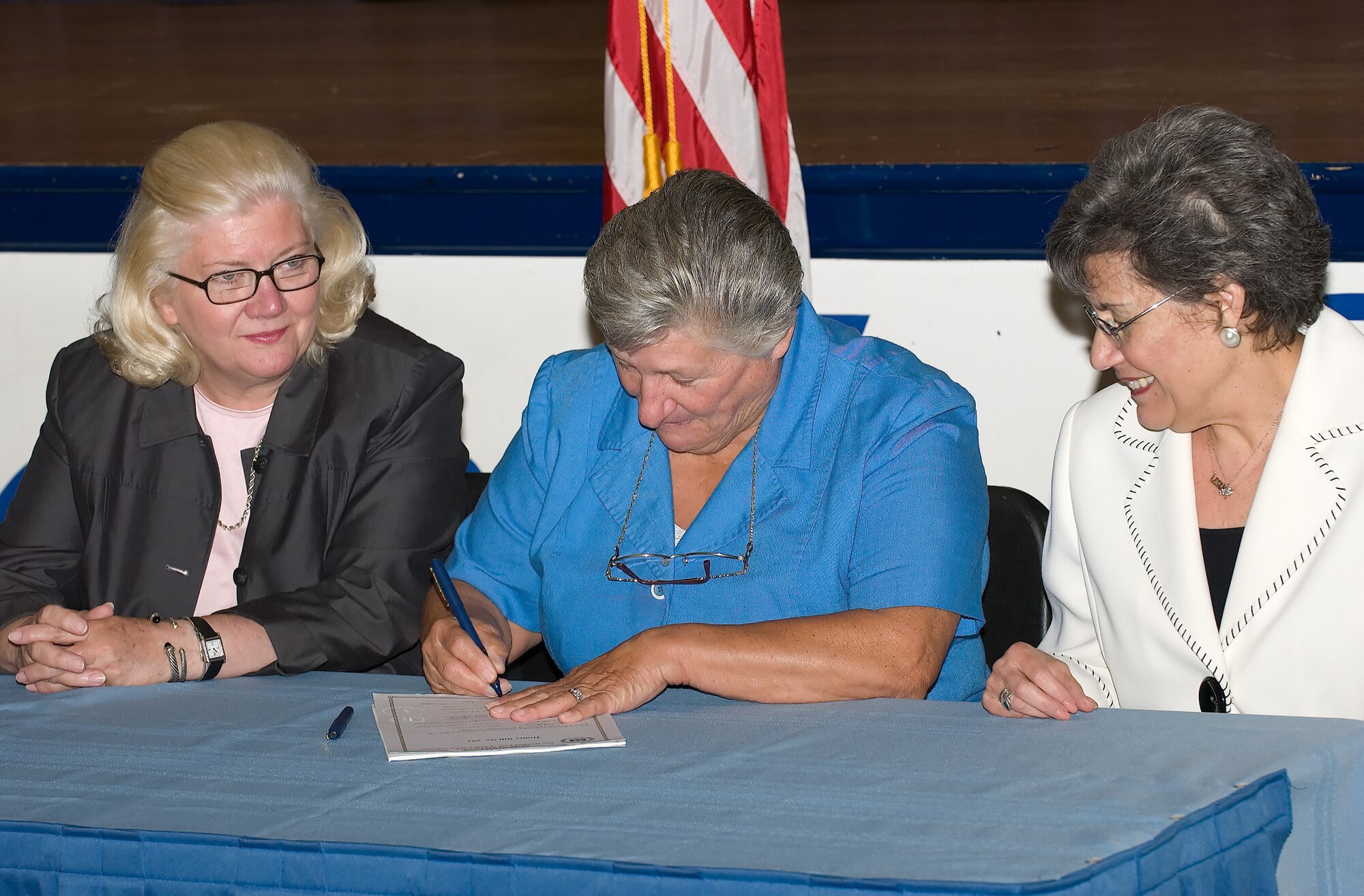 DOVER , Del. -- Representative Nancy Wagner, 31st District, Del., left, and Leslye Arsht, deputy under secretary of defense for military community and family policy, right; sit with Delaware Governor Ruth Ann Minner as she signs House Bill 297, the Compact for Education Transition for Military Children, at a ceremony at Dover High School Thursday.  Delaware was the tenth state to sign the Compact, thus activating it and making educational transitions for active-duty military families easier among states participating in the Compact. (U.S. Air Force photo/Jason Minto)