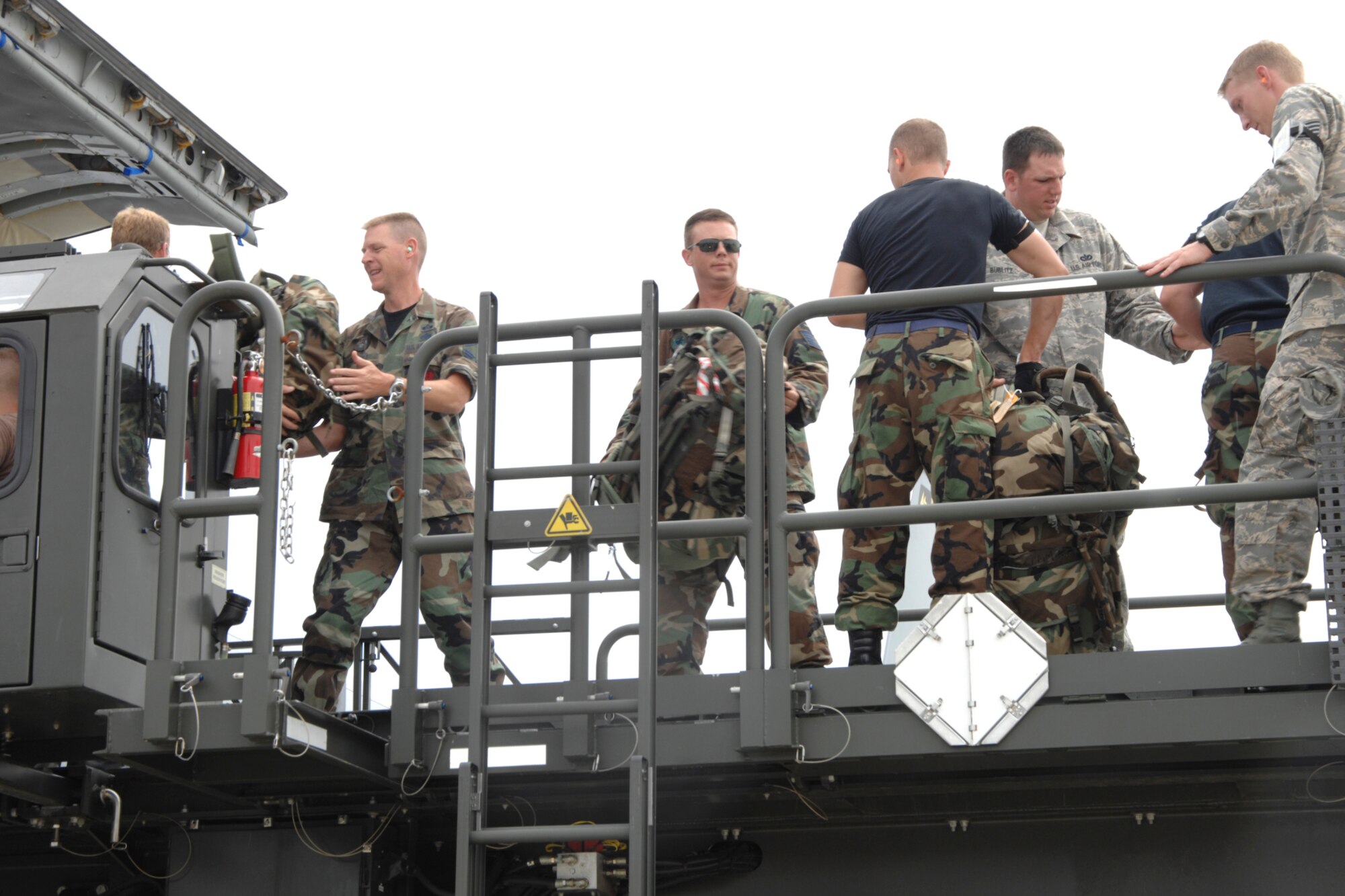 Airmen of the 127th Civil Engineer Squadron returning from a Silver Flag exercise at Tyndall AFB, Fla., assist the 171st Aerial Port Flight in offloading baggage from their plane on July 12 at Selfridge Air National Guard Base, Mich.