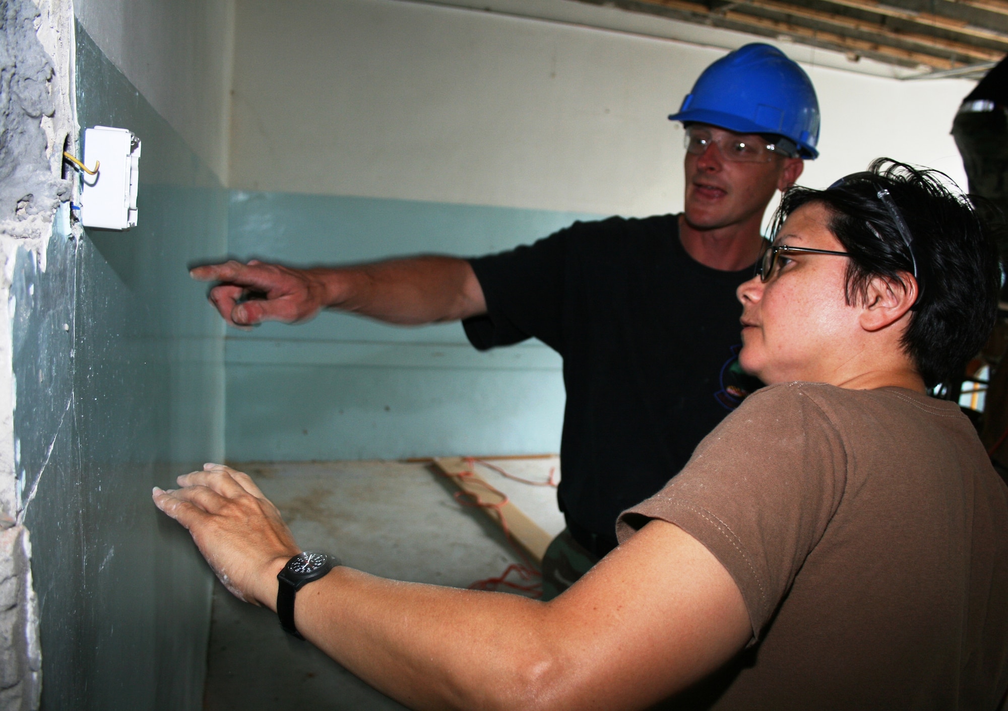 Master Sgt. Cathy Burns, a member of the Maryland Air National Guard’s 175th Civil Engineer Squadron, drills a hole for mounting a light switch at a primary school in Vlasenica, Republika Srpska, Bosnia-Herzegovina July 15, 2008, as part of a humanitarian civic action project under the auspices of the National Guard’s State Partnership Program. (U.S. Air Force photo by Capt. Wayde R. Minami)
