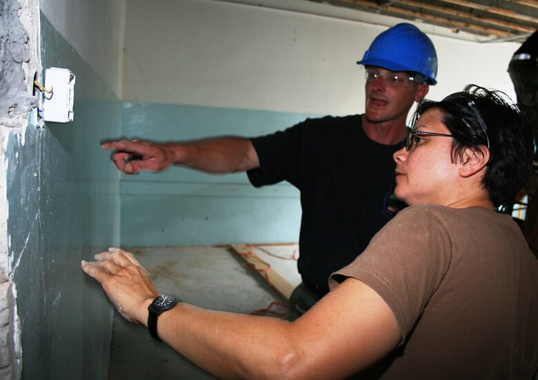 Master Sgt. Cathy Burns, a member of the Maryland Air National Guard’s 175th Civil Engineer Squadron, drills a hole for mounting a light switch at a primary school in Vlasenica, Republika Srpska, Bosnia-Herzegovina July 15, 2008, as part of a humanitarian civic action project under the auspices of the National Guard’s State Partnership Program. (U.S. Air Force photo by Capt. Wayde R. Minami)
