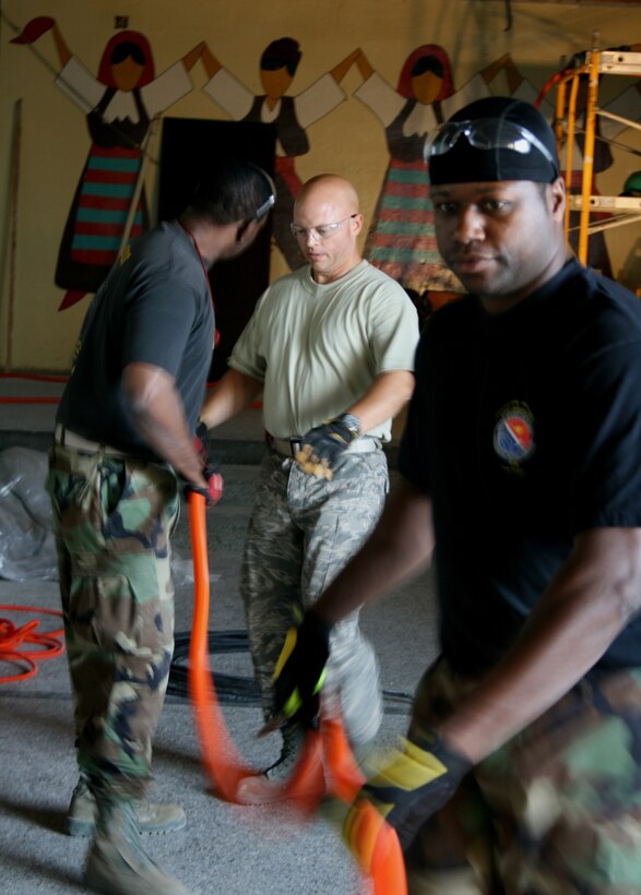 Master Sgt. Darryl S. Ennels, Senior Airman Robert E. Gillium and Staff Sgt. Tory M. Greer, members of the Maryland National Guard’s 175th Civil Engineer Squadron, install flexible conduit for a new electrical system at a primary school in Vlasenica, Republika Srpska, Bosnia-Herzegovina July 15, 2008, as part of a humanitarian civic action project under the auspices of the National Guard’s State Partnership Program. . (U.S. Air Force photo by Capt. Wayde R. Minami)

