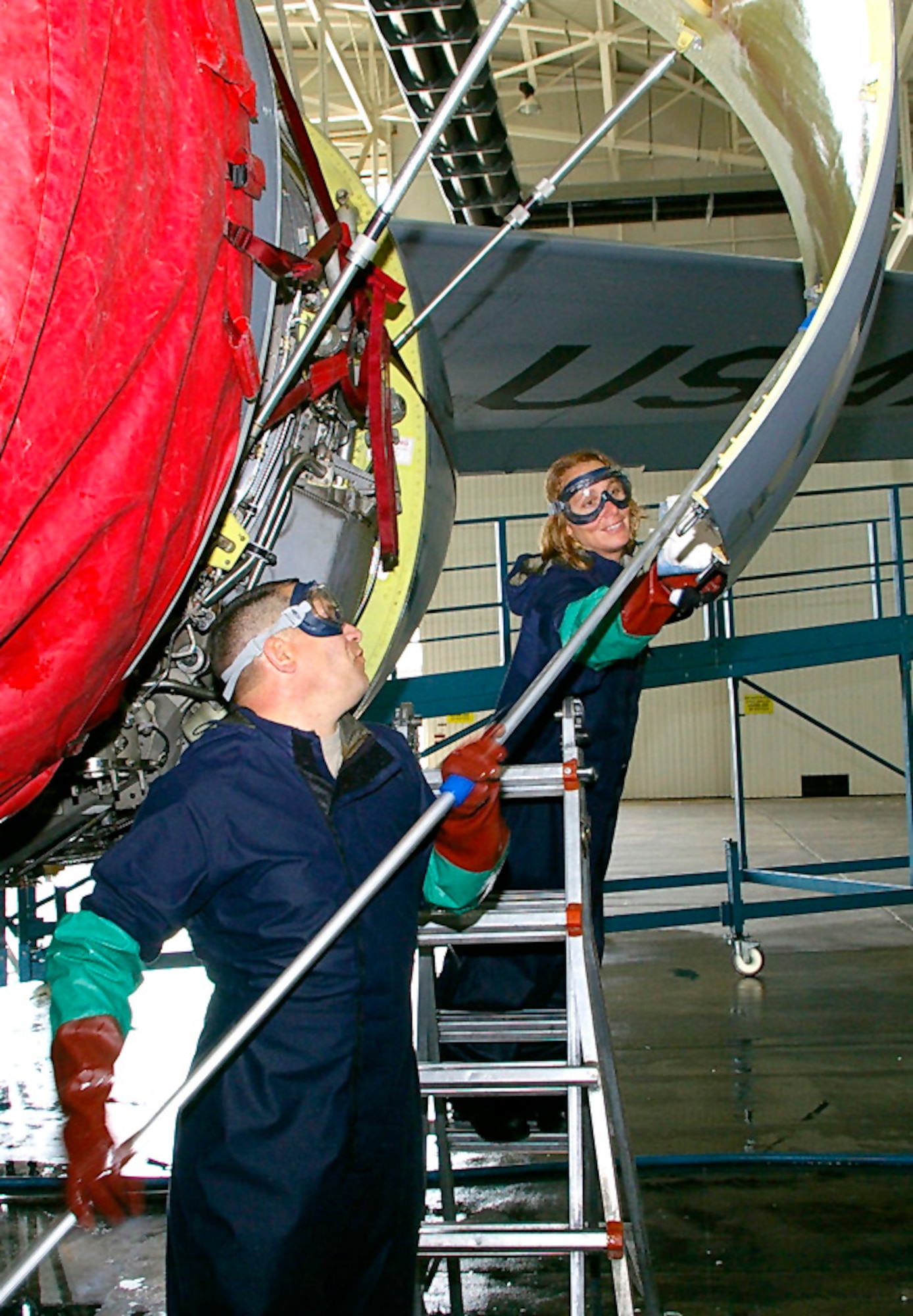 RAF MILDENHALL, England -- Senior Master Sgt. John Frazier, 100th Aircraft Maintenance Squadron AMU superintendent, and Maj. Jill Murphy, 100th AMXS operations officer, wash the inside of a KC-135 engine cowling July 14 during a fundraiser to support the Air Force Ball in September. (U.S. Air Force photo by Karen Abeyasekere)