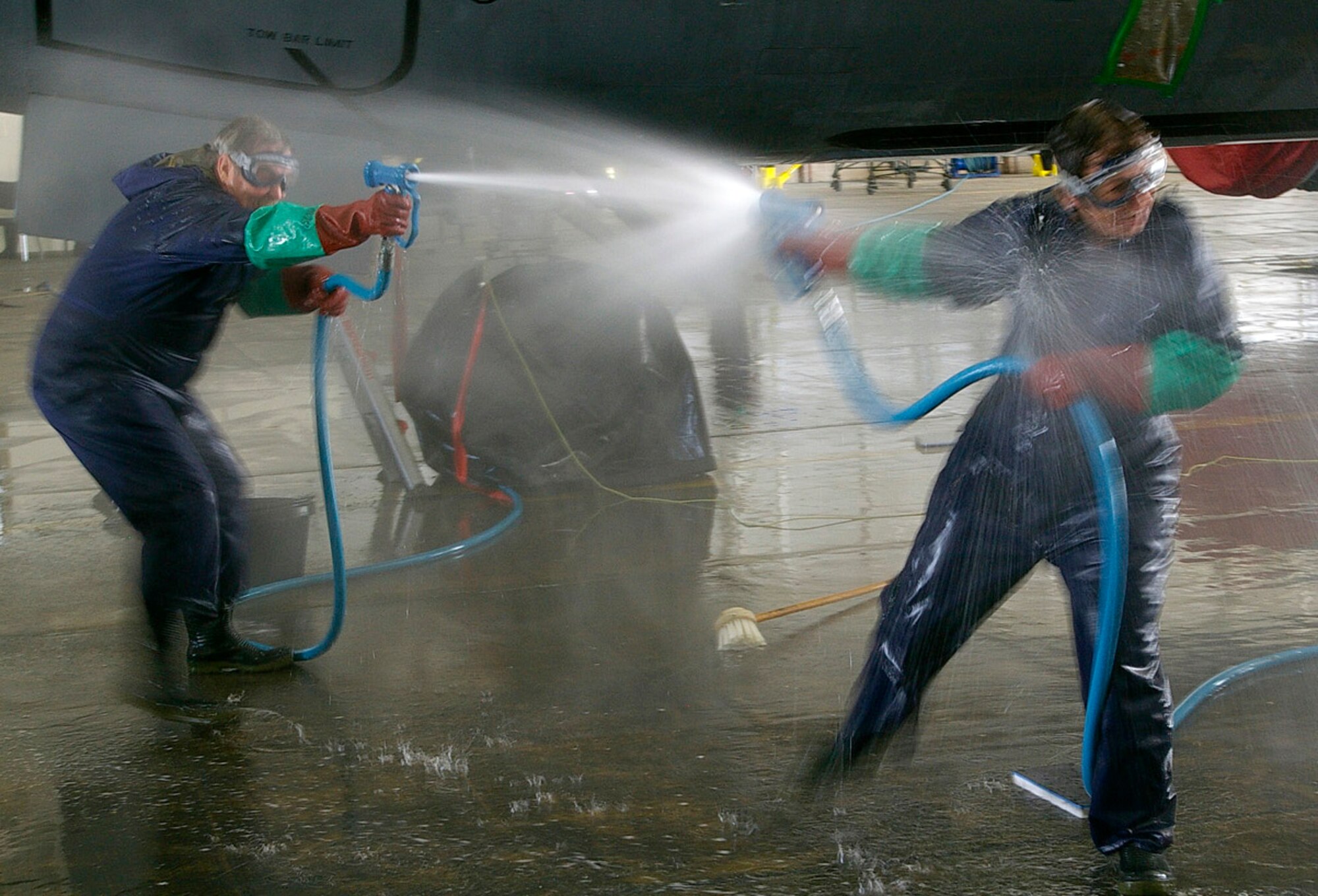 RAF MILDENHALL, England -- Michael Fitzmaurice, 100th Force Support Squadron, and Vicki Stayton, RAF Mildenhall community relations advisor, hose eachother down during while scrubbing a KC-135 July 14 during a fundraiser to support the Air Force Ball in September. It cost $1 per vote to nominate someone, and the event raised $3,100 total. The proceeds will be used to defray the cost of tickets for the ball. (U.S. Air Force photo by Karen Abeyasekere)