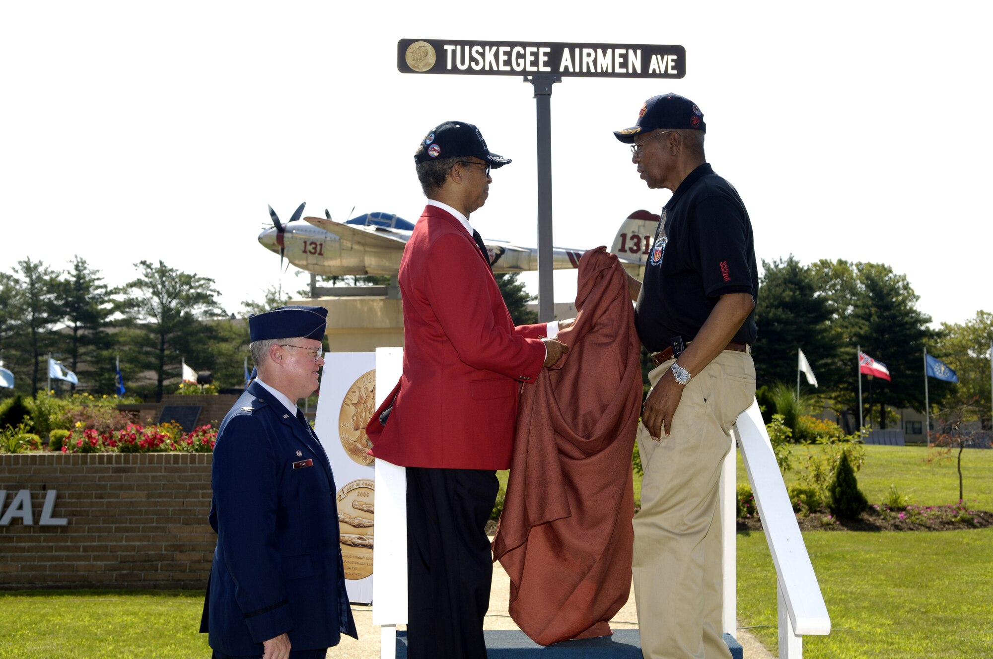 Lt. Gen. (ret) Russell Davis (left), national president of Tuskegee Airmen, Incorporated, and Master Sgt. (ret) Shade Lee, a documented original Tuskegee Airman, unveil a new street sign featuring an image of the Congressional Gold Medal at the McGuire Air Force Base rededication of Tuskegee Avenue July 17. The ceremony, which was part of the 37th Tuskegee Airmen National Convention being held July 17 through July 20 in Philadelphia, was held in honor of the Tuskegee Airmen's significant accomplishments, which include the Congressional Gold Medal awarded in March 2007. (U.S. Air Force photo/Kenn Mann)