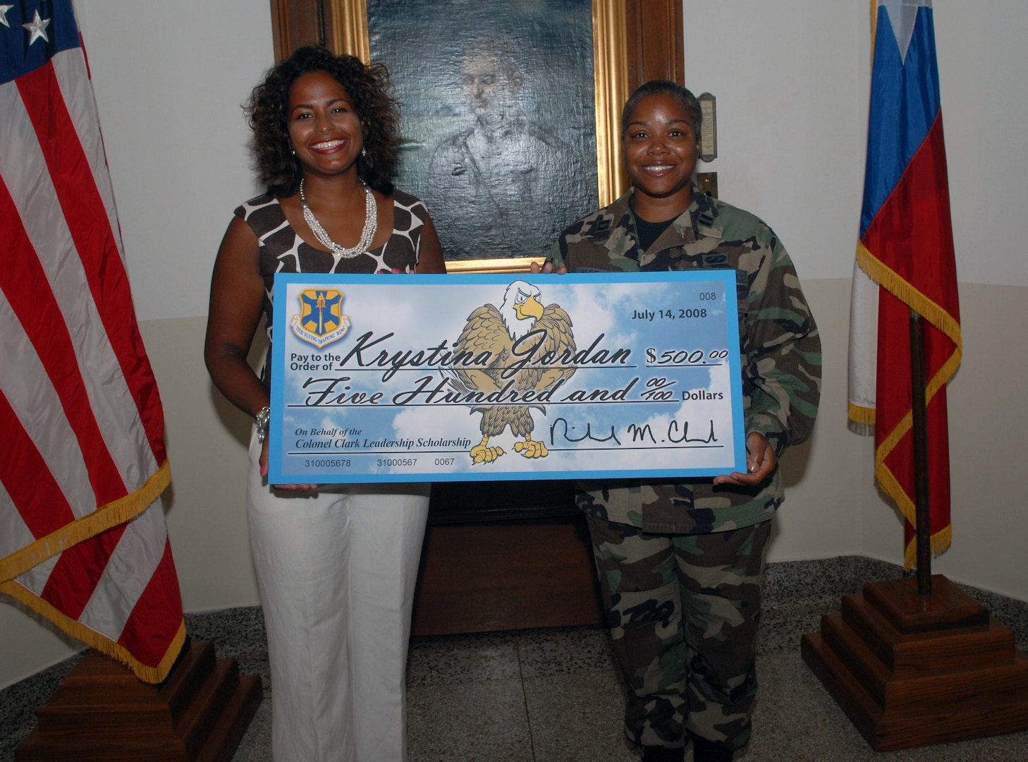Mrs. Amy Clark, wife of former 12th Flying Training Wing commander, Col. Richard Clark, presents the first Colonel Clark Leadership Scholarship fund check for $500 to Capt. Krystina Jordan July 16 in the Taj Mahal. (U.S. Air Force photo by Rich McFadden)