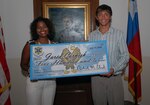 Mrs. Amy Clark, wife of former 12th Flying Training Wing commander, Col. Richard Clark, presents the first Colonel Clark Leadership Scholarship fund check for $500 to Jared Cornish July 16 in the Taj Mahal. (U.S. Air Force photo by Rich McFadden)