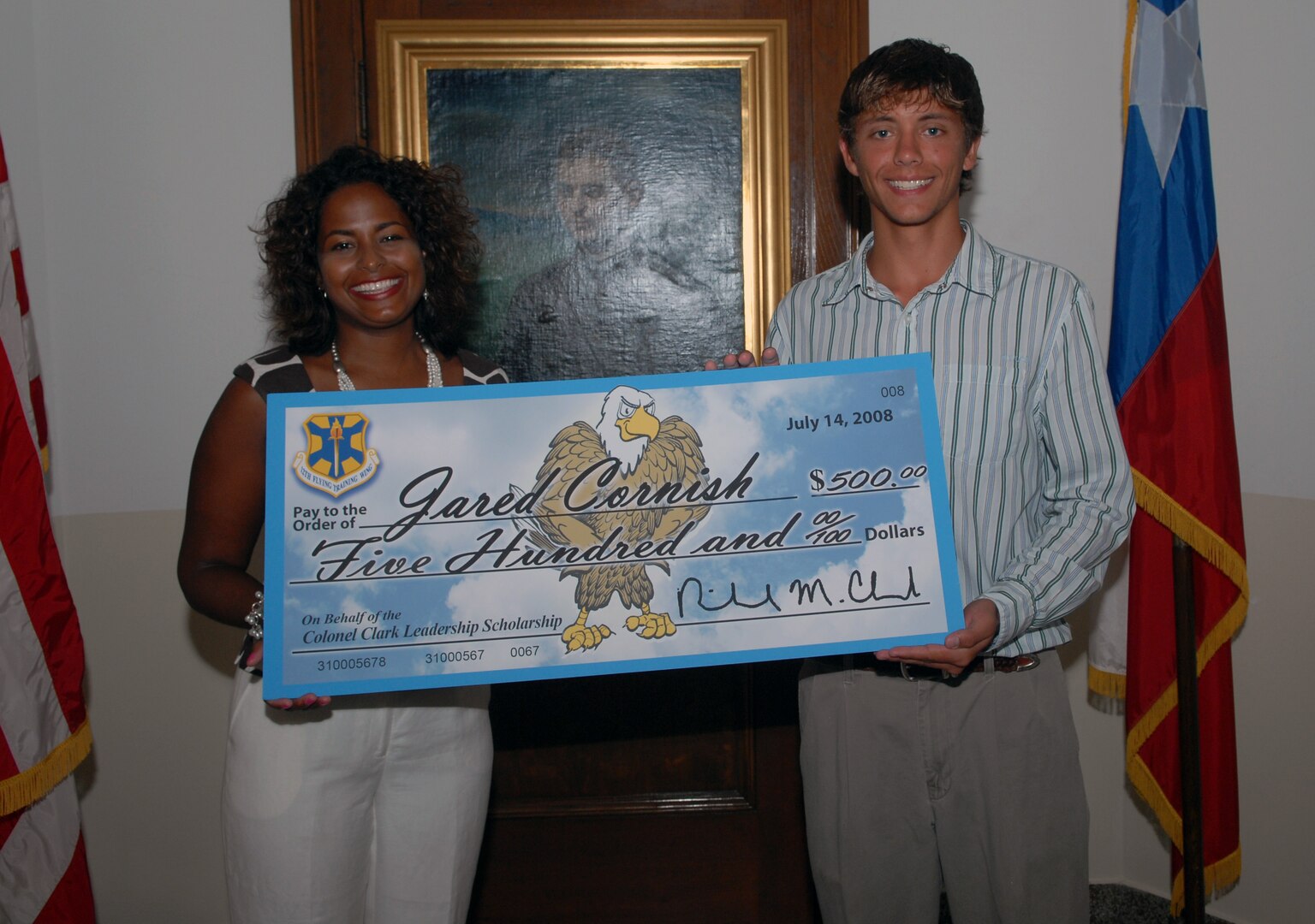 Mrs. Amy Clark, wife of former 12th Flying Training Wing commander, Col. Richard Clark, presents the first Colonel Clark Leadership Scholarship fund check for $500 to Jared Cornish July 16 in the Taj Mahal. (U.S. Air Force photo by Rich McFadden)