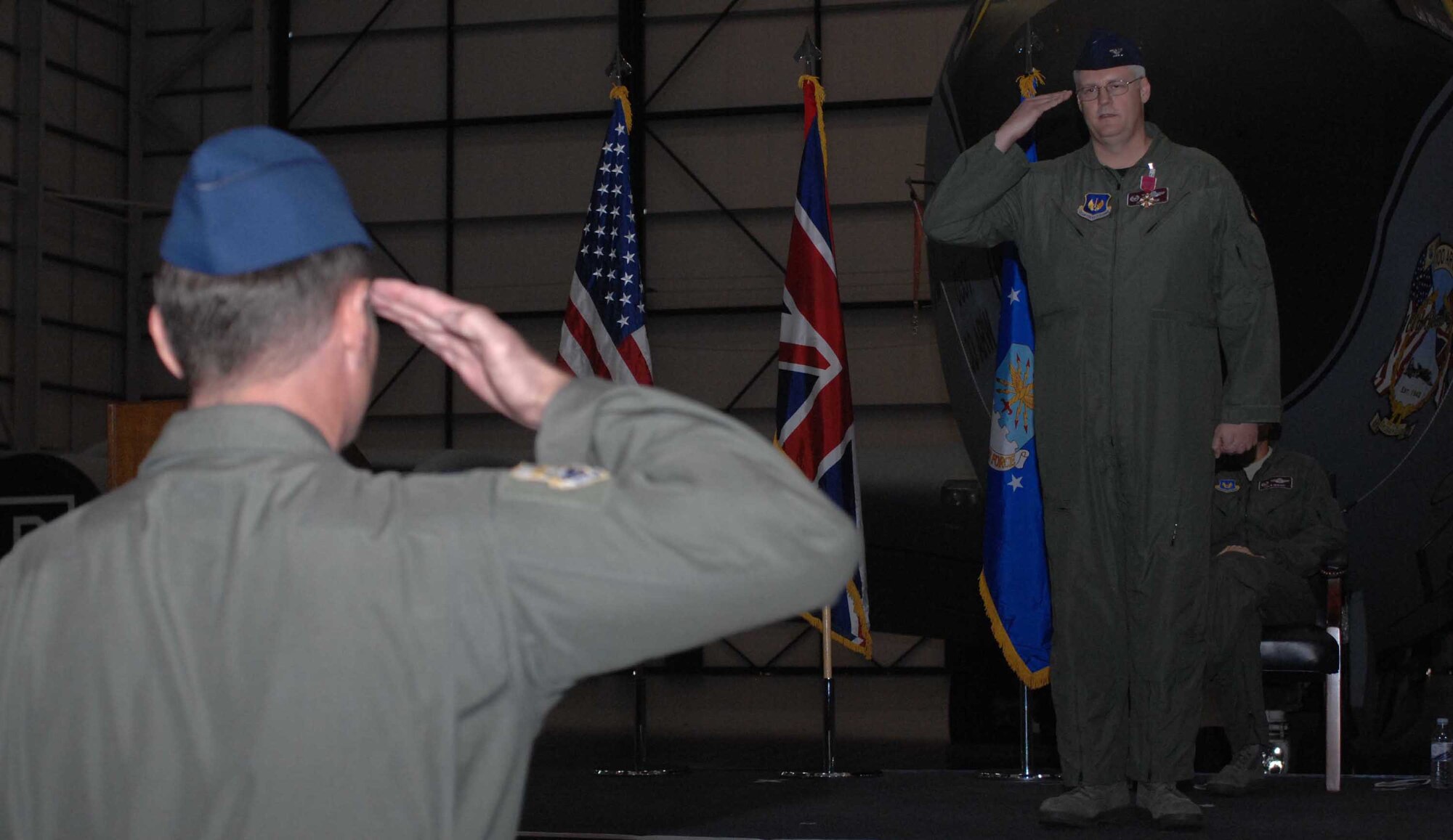 RAF MILDENHALL, England -- Col. James Clifton gives his symbolic last salute to members of the 100th Operation Group troops during a change of command ceremony July 17. He relinquished command of the group to Col. Creg Paulk, who recently arrived to RAF Mildenhall from Cheyenne Mountain Air Force Station, Colo. (U.S. Air Force photo By Airman 1st Class Brad Smith)