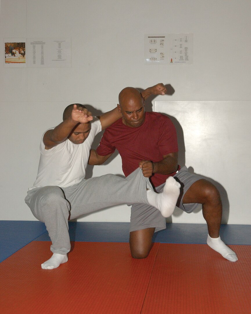 7/15/2008 - Danilo Sanchez, left, a Defense Language Institute student from the Dominican Republic, practices self defense skills with Joel Jones, a lieutenant colonel and the 37th Mission Support Squadron commander. Jones teaches the self defense class twice a week. (USAF photo by Alan Boedeker)                               