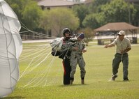 7/9/2008 - After completing a tandem parachute jump July 9, Staff Sgt. Nicholas Seibel, 342nd Training Squadron, helps Master Sgt. Timothy Kane, 37th Security Forces Squadron, take off their parachute. (USAF photo by Robbin Cresswell)   