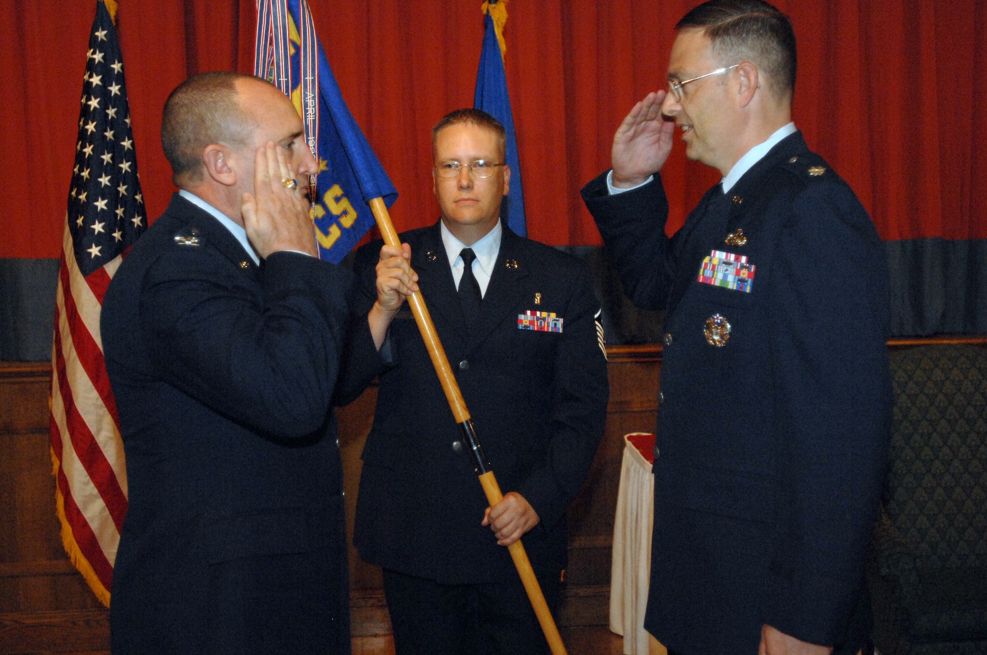 RAF MILDENHALL, England -- Col. Jeffery Bateman (left), 100th Mission Support Group commander, passes command of the 100th Communications Squadron to Lt. Col. David Stookey July 17. Lt. Col. Stookey, who recently arrived from a 1-year tour in Southwest Asia, assumes command from Lt. Col. Karl Kraan who leaves RAF Mildenhall for a new assignment at the Pentagon. (U.S. Air Force photo by Senior  Airman Teresa M. Hawkins)