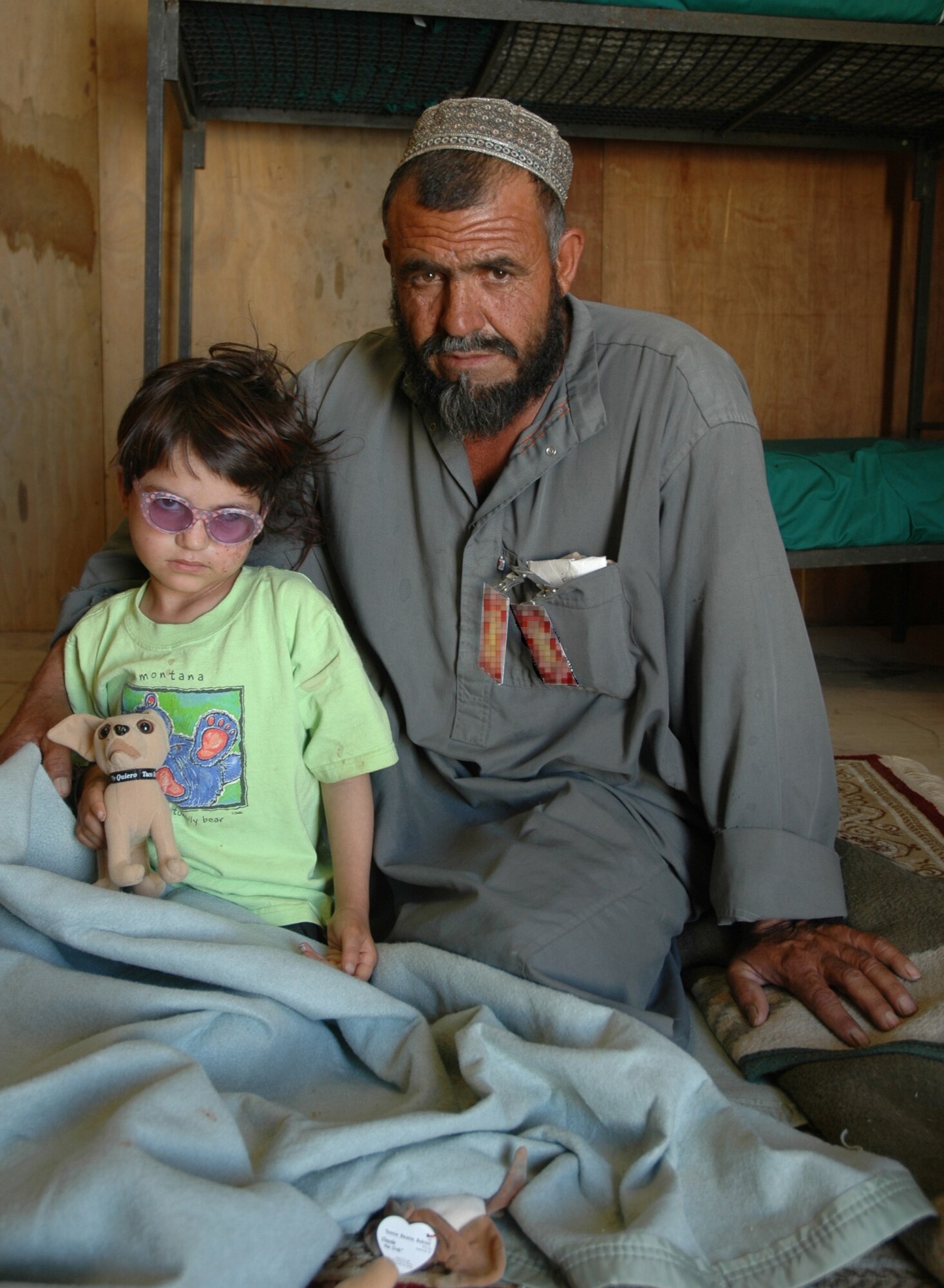 BAGRAM AIR FIELD, Afghanistan -- Gulzana Haqim and her father, Abdullah, pose for a photo during her recovery period at Bagram Air Field, Afghanistan, July 11. Gulzana was diagnosed with a tumor over her eye - an affliction that has an extremely low chance of survival in Afghanistan. However, Coalition doctors treated her and she is on her way to recovery. (Photo by Army Sgt. Daniel Love)