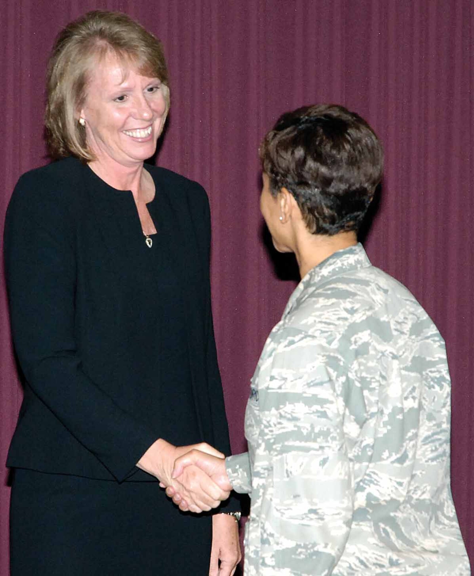 Col. Mona Lisa Tucker, 72nd Air Base Wing vice commander, congratulates Stacy Cameron, the new 72nd Communications Squadron director.  Ms. Cameron, the squadron's first civilian leader, replaced outgoing commander Lt. Col. Kyna McCall July 2.  (Air Force photo oby Dave Faytinger)