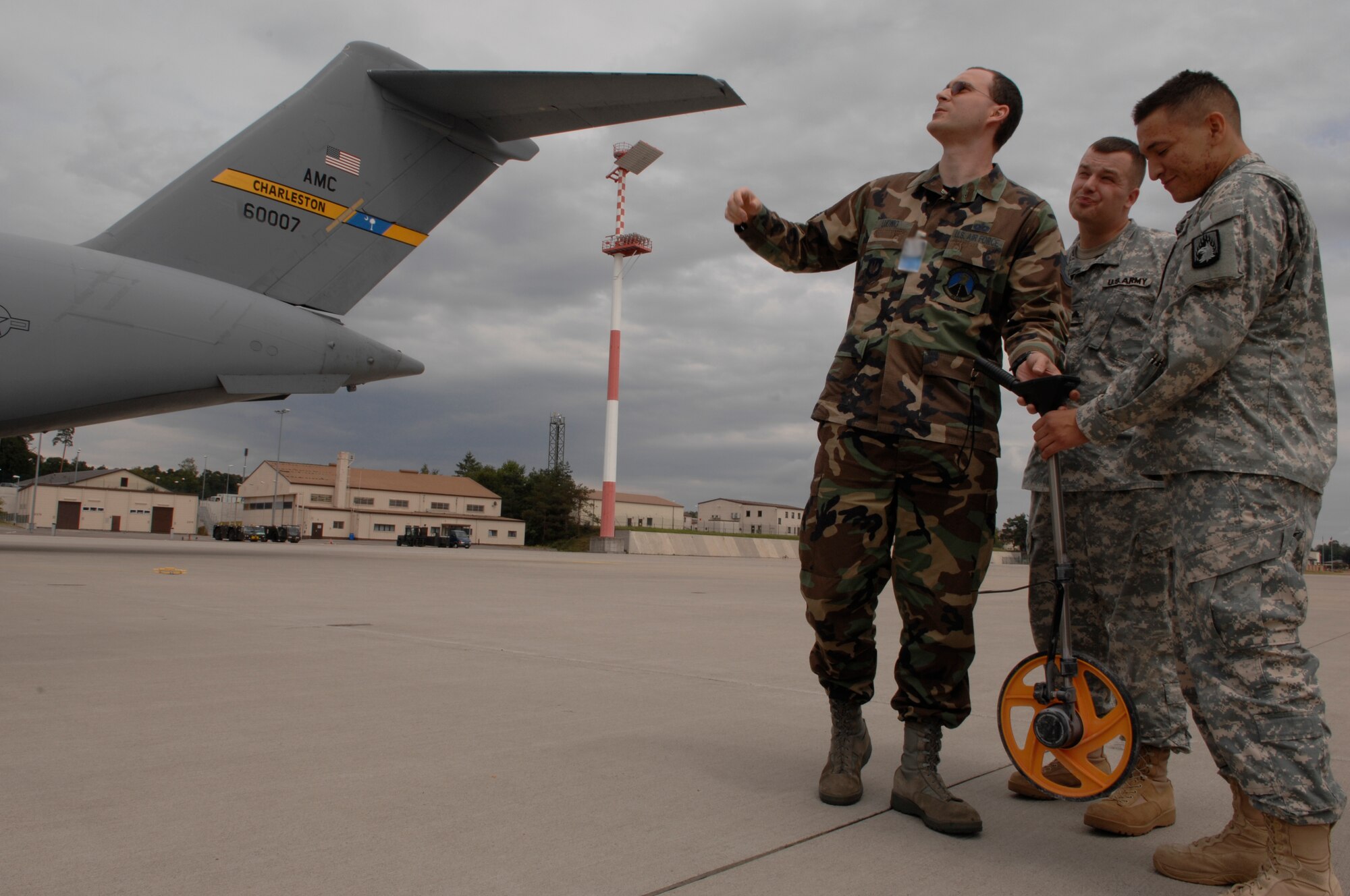Tech. Sgt. Matthew Ludwig (left), 86th Operations Support Squadron airfield manager, trains U.S. Army Sgt. Jason Johns and Pfc. Ricardo Farias, 3d Battalion, 58th Aviation Regiment, Illsheim, Germany, how to take wing tip measurements, July 17, 2008, Ramstein Air Base, Germany.  Airfield managers from the 86th OSS are training Army Soldiers in a first-ever Department of Defense pilot program. (U.S. Air Force photo by Senior Airman Amber Bressler)(Released)
