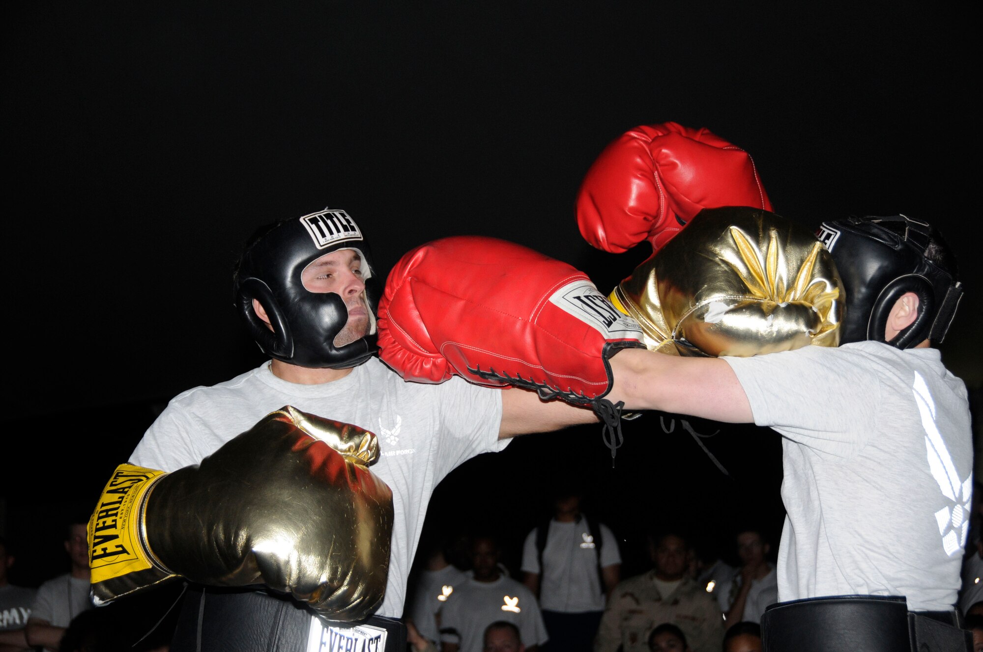 Senior Airman Bradley Keszler, 379th Expeditionary Communications Squadron, jabs 2nd Lt. Mark Manglcmot, 379 ECS, during Friday Night Fights July 11 Southwest Asia. Friday Night Fights is a once a month event where servicemembers compete against each other wearing oversized gloves. Senior Airman Keszler is deployed from Lajes Field, Azores, and Leiutenant Manglicmot is deployed from Schriever Air Force Base, Colo. (U.S. Air Force photo by Staff Sgt. Darnell T. Cannady)
