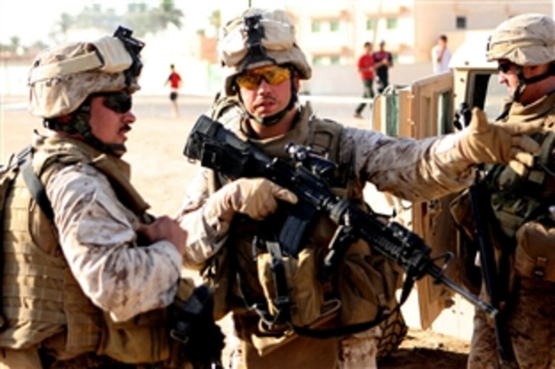 U.S. Marine Corps Sgt. David J. Neukirchen, center, talks with another Marine about training during a combined medical engagement exercise in Mudiq, Iraq, July 6, 2008. Neukirchen is a squad leader assigned to Company F, 2nd Battalion, 24th Marine Regiment, Regimental Combat Team 1.
