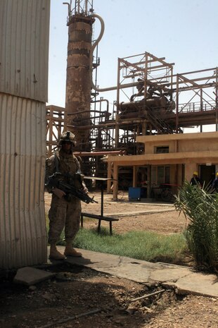 Lance Cpl. Moises Garcia, a squad automatic weapon machine gunner with Company K, 3rd Battalion, 4th Marine Regiment, Regimental Combat Team 5, stands guard at the K3 Oil Refinery near Haditha, Iraq, July 18. The opening of the refinery was celebrated at a ceremony where over 100 government and community leaders gathered along with Coalition forces. The refinery, capable of processing 16,000 barrels of crude oil per day had been non-operational for three years until Coalition forces and Iraqi government leaders stepped in to repair it. The refinery will make the Al Anbar province capable of meeting its fuel needs and will eventually provide fuel for a power station, which will supply the entire Al Anbar province with an ample supply of electricity. ::r::::n::