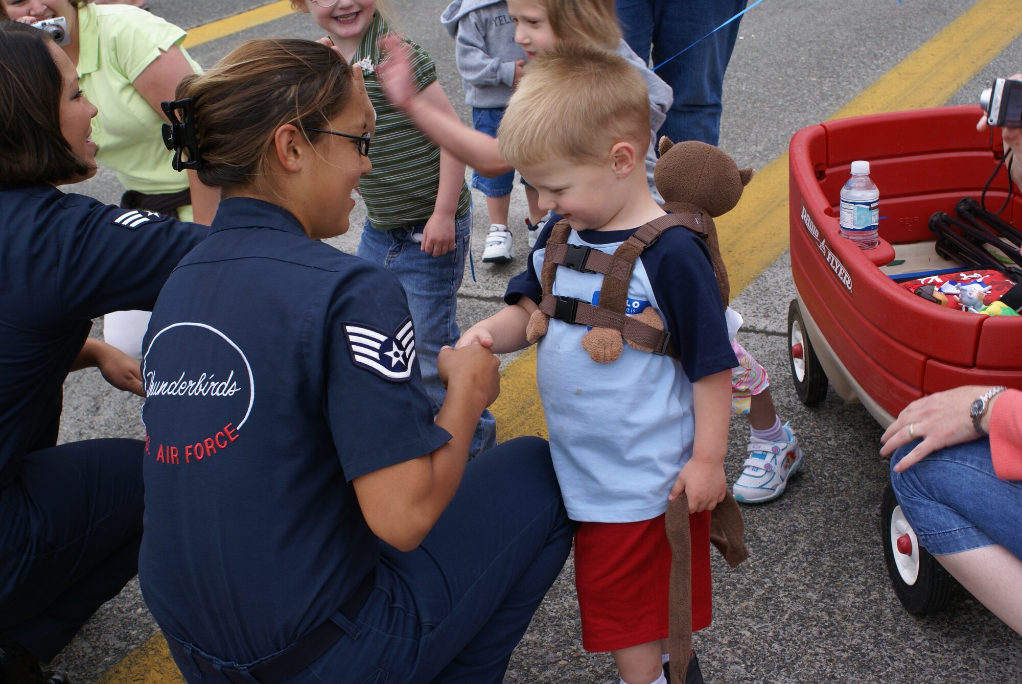 An enlisted Thunderbird member shakes hands with a little boy during McChord's Special Needs Day 2008 July 18 here. The Thunderbirds Demonstration Squadron will perform Saturday and Sunday afternoon. (U.S. Air Force Photo/Airman 1st Class Bethany Pattee.)
