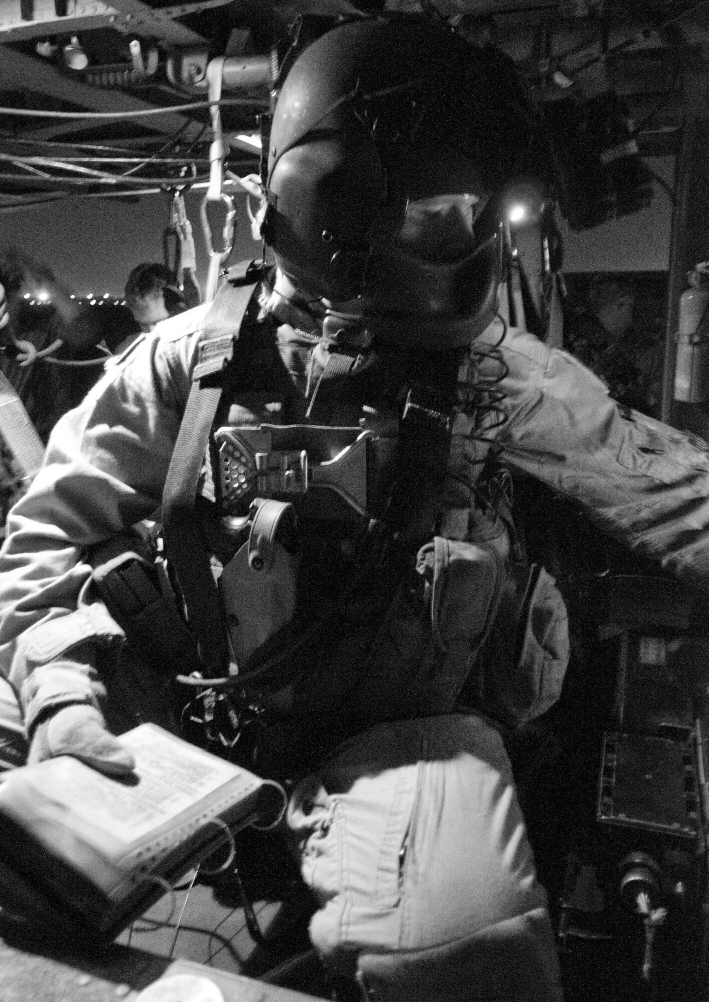BAGRAM AIR FIELD, Afghanistan -- Airman 1st Class Devin Chesbro, 33rd Expeditionary Rescue Squadron flight engineer, runs preflight checklists here on July 17, 2008.  Airman Chesbro is tasked with operational support to pilots as well as manning one of the two .50 caliber machine guns. Airman Chesbro is deployed from the 33rd Rescue Squadron, Kadena Air Base, Japan. (U.S. Air Force photo by Staff Sgt. Samuel Morse)