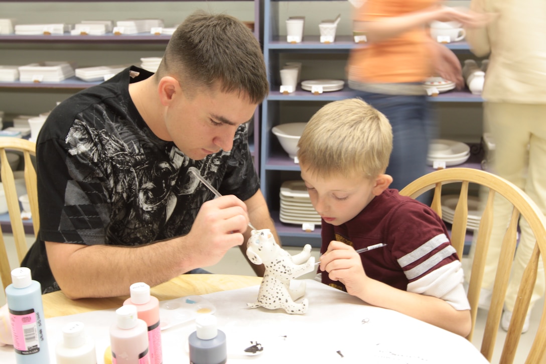 Sgt. Dennis Evey, training noncommissioned officer, survey/meteorological section, 11th Marine Regiment, 1st Marine Division, paints with nephew Branson Trosper, at Camp Pendleton's Arts and Crafts Hobby Shop, Jan. 17. The hobby shop is available to service and family members, retirees, sponsored guests and Department of Defense civilian employees. Regular hours of operation are Wednesday to Friday, 12 p.m. to 8 p.m. and 9 a.m. to 5 p.m., Saturday and Sunday. It is located on Mainside, bldg 13113.::r::::n::