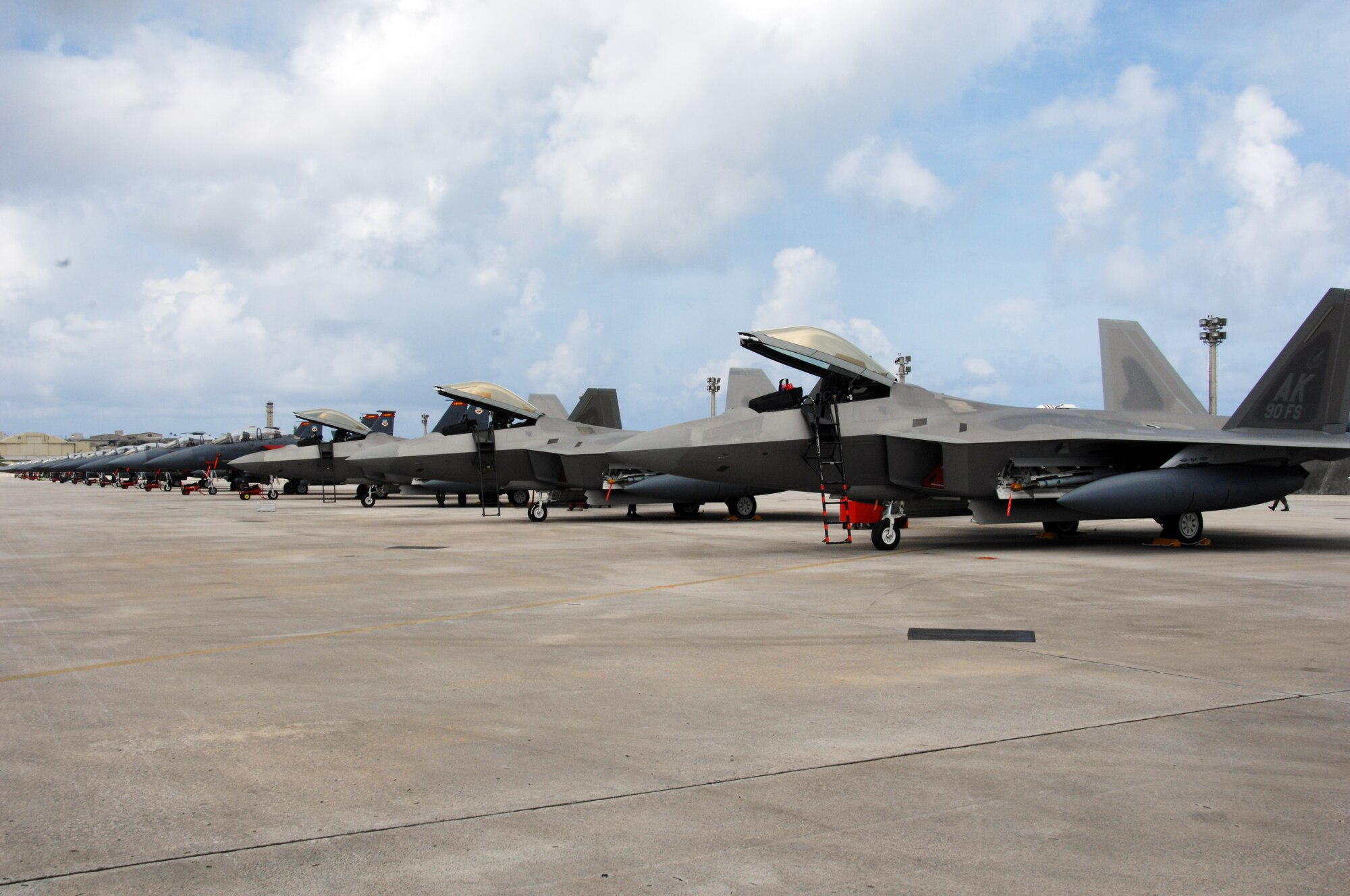 Five U.S. Air Force F-22A Raptors join 16 F-15E Strike Eagles on the flightline at Andersen Air Force Base, Guam, July 20. Although this is the second time that F-22A's have been deployed to Guam, this is the first time F-22A’s assigned to the 90th Expeditionary Fighter Squadron Elmendorf Air Force Base, Alaska have come here.  (U.S. Air Force by Airman 1st Class Nichelle Griffiths)