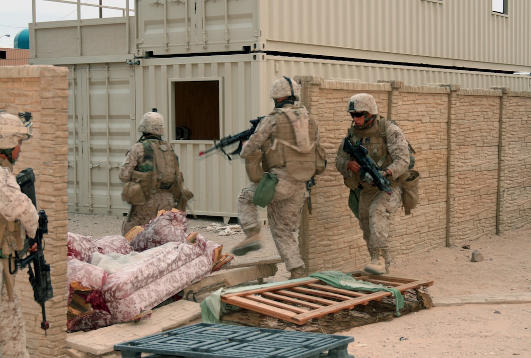 Lance Cpl. Daniel Ledogar (right) directs his fire team into a courtyard to clear a house of insurgents during a training exercise at an urban warfare training facility here July 20, 2008.  Reserve Marines from Company G, 2nd Battalion, 25th Marine Regiment are conducting operations here in preparation for a fall deployment to Iraq.