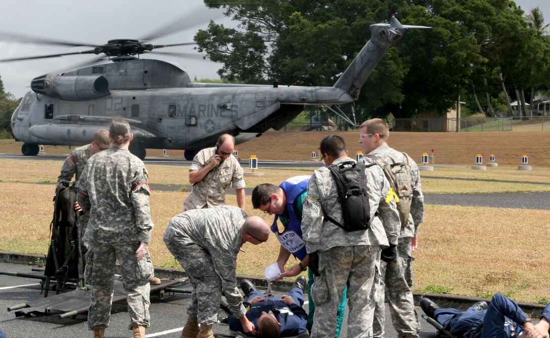 As medical units attend to patients, Maj. Mark Merrill, safety observer for HMH-362,(center) radios in for lift off of a CH-53 after dropping off casualties from the USS O'Kane during a mass casualty exercise for the 2008 RIMPAC Exercise here July 21.
