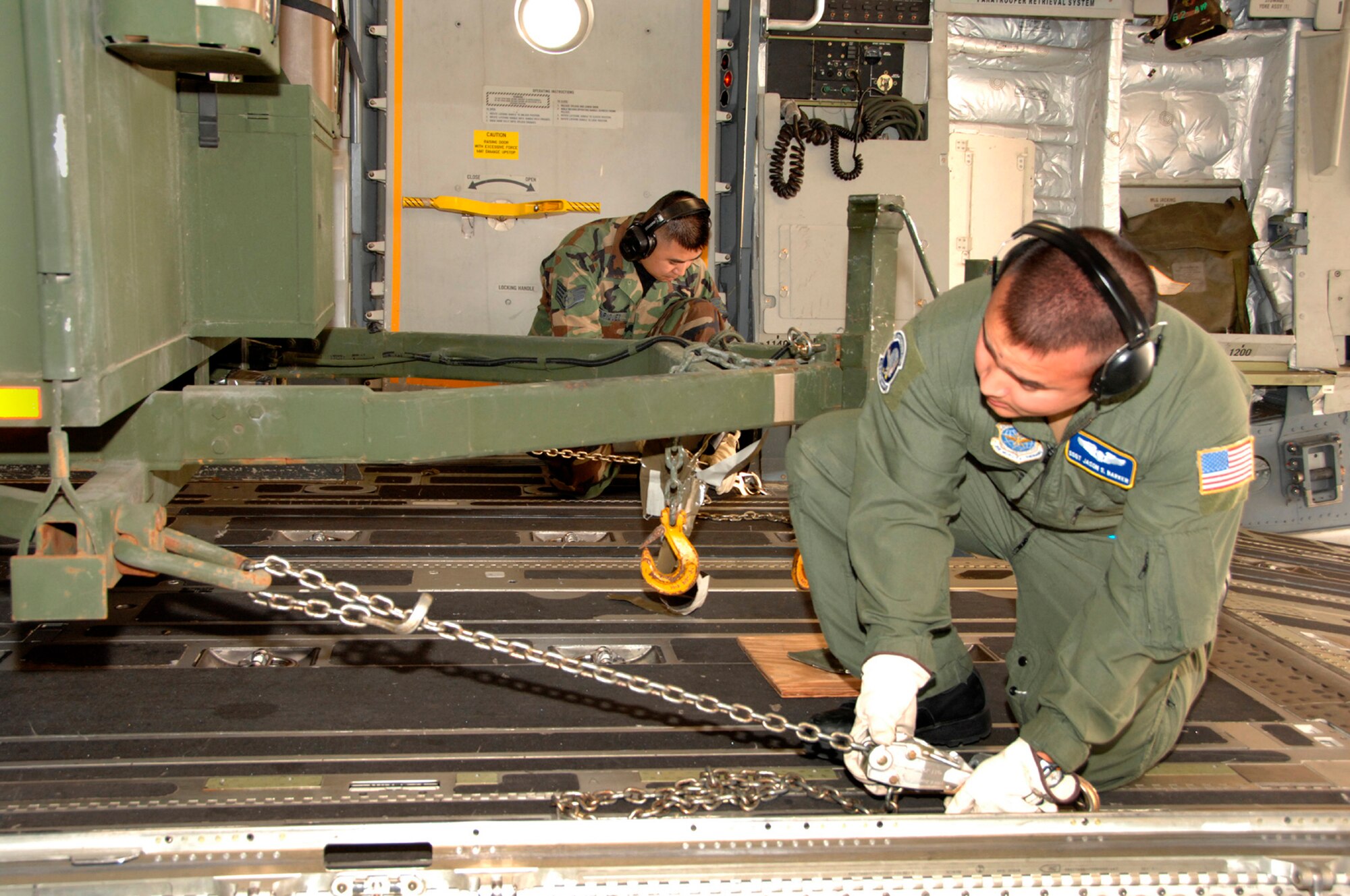 TRAVIS AIR FORCE BASE, Calif. -- Staff Sgt. Jason Barker, C-130 Loadmaster with the 615th Contingency Response Wing, and Staff Sgt. Greg Enriquez, ramp specialist with the 45th Aerial Port Squadron, load and secure equipment on a Team Travis C-17 Globemaster III, July 13, deploying in Hydra Exercise ‘08. During the 615th CRW’s seven-day exercise, more than 1,000 Airmen, soldiers, and Marines will build up bare bases at five central California airfields and train to rapidly respond to a humanitarian disaster. (U.S. Air Force photo / Master Sgt. Wendy Weidenhamer)