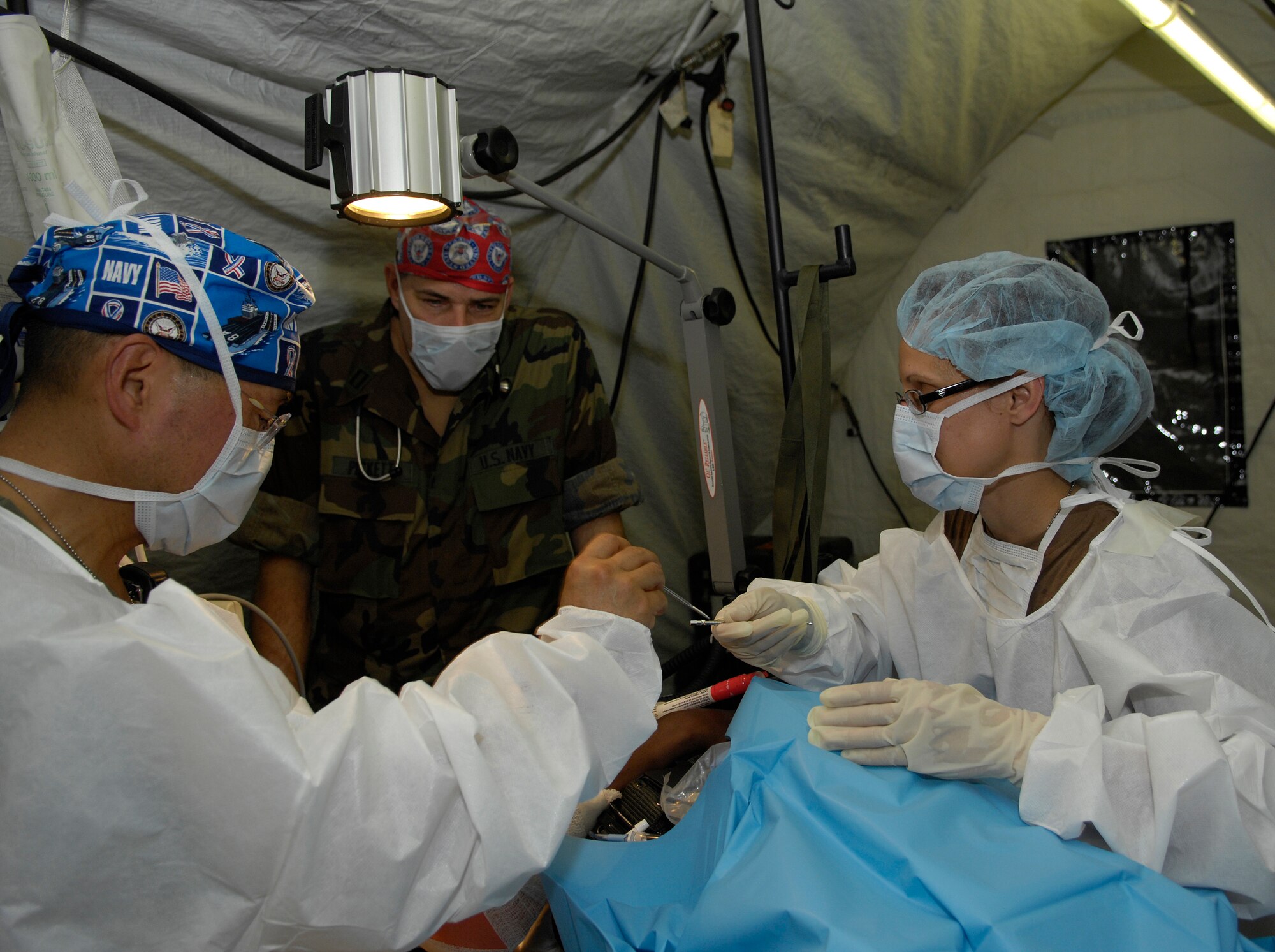 BAMAKO, Mali - Lt. Cmdr. Terry Lein passes Capt. William Oh a pin to insert in a "broken arm" during the Mass Casualty portion of MEDFLAG 08, July 18, 2008.  More than 90 servicemembers deployed to Bamako, Mali, for MEDFLAG 08, a multi-national medical training exercise designed to enhance medical capabilities and readiness for U.S. and African Forces.  Captain Oh is deployed from Naval Operational Support Unit, Toledo, Ohio.  Commander Lein is deployed from the Operational Hospital Support Unit, Camp LeJeune HQ, N.C.  (U.S. Air Force photo/Senior Airman Michael S. Dorus)