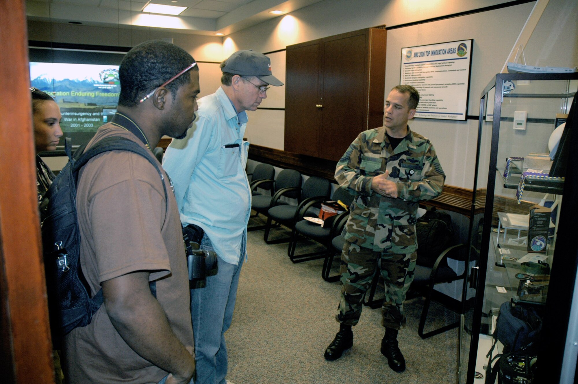 Master Sgt. Michael Harris describes some battlelab initiatives to Tatiana El-Khouri, Steven Wright and John Finger -- all artists participating in an official visit to the USAF EC as part of the Air Force Art Program. During a three-day visit, the artists saw the armory, the center campus and in-the-field training for Phoenix Warrior and Eagle Flag courses. Sergeant Harris is assigned to the U.S. Air Force Expeditionary Center's Air Mobility Battlelab. (U.S. Air Force Photo/Tech. Sgt. Scott T. Sturkol)