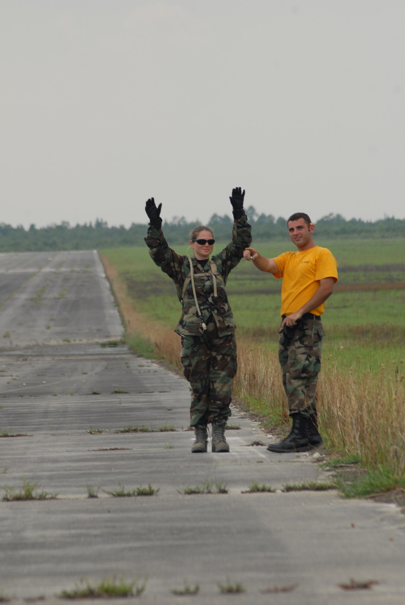2nd Lt. Leslie Balcazar, 60th Medical Diagnostics and Theraputic Squadron, receives instruction from Staff Sgt. Marcello Mennone, 43rd Aeromedical Evacuation Squadron, on how to correctly marshal in an approaching aircraft during Mobile Aeromedical Staging Facility training at Fort Bragg's Camp Mackall July 10. (U.S. Air Force Photo by Staff Sgt. Jon LaDue)