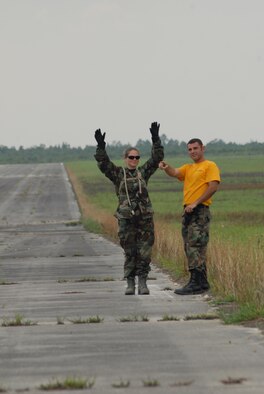 2nd Lt. Leslie Balcazar, 60th Medical Diagnostics and Theraputic Squadron, receives instruction from Staff Sgt. Marcello Mennone, 43rd Aeromedical Evacuation Squadron, on how to correctly marshal in an approaching aircraft during Mobile Aeromedical Staging Facility training at Fort Bragg's Camp Mackall July 10. (U.S. Air Force Photo by Staff Sgt. Jon LaDue)