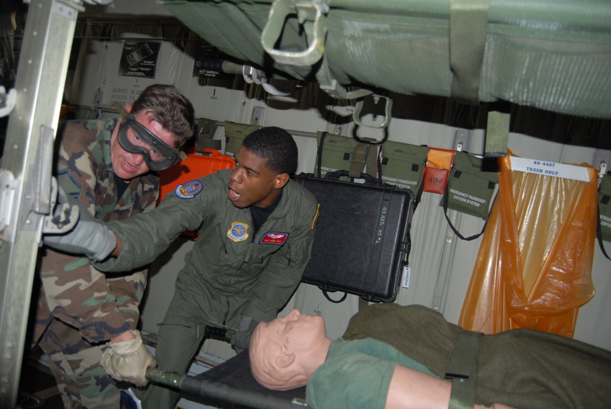Master Sgt. Benjamin Kratzer, 60th Medical Operations Squadron, listens while Tech. Sgt. Jaime Tate, 375th Aeromedical Evacuation Squadron, explains how to load litters on to a C-130 during Mobile Aeromedical Staging Facility training at Fort Bragg's Camp Mackall July 10. (U.S. Air Force Photo by Staff Sgt. Jon LaDue)