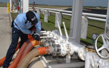 Aree Pulliam, a fuels technician with Defense Contract Services, Inc., prepares a fuels storage system to download JP-8 jet fuel July 17. (U.S. Air Force photo by Rich McFadden)