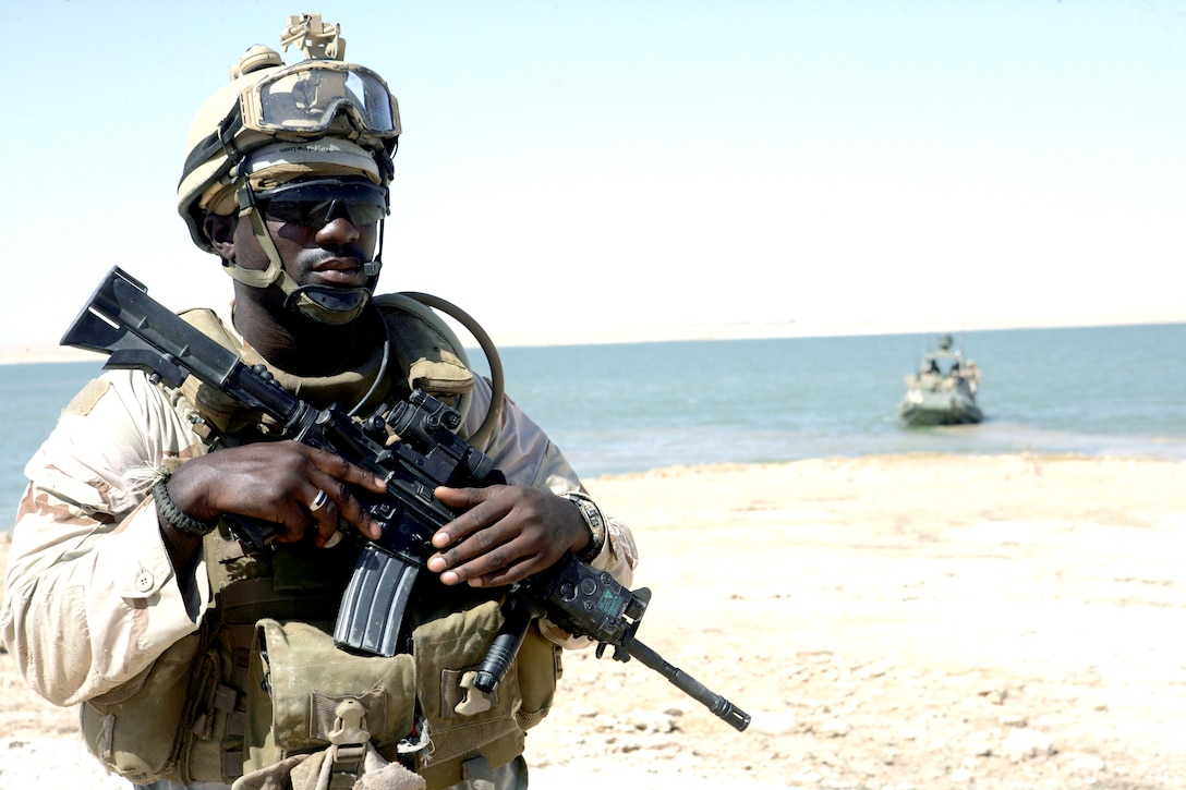 U.S. Navy Seaman Samuel Duodu posts a security watch as he and his fellow riverines prepare to be extracted in a riverine patrol boat from the Watah Peninsula near Rawah, Iraq, July 11, 2008. 