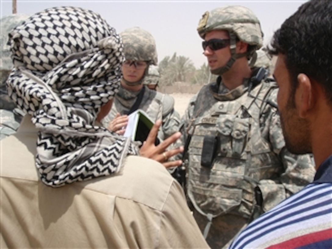 U.S. Army Staff Sgt. Jonathan Conery, a civil affairs specialist from Alpha Company, 2nd Battalion, 30th Infantry Regiment, 4th Brigade Combat Team, 10th Mountain Division, talks to local business owners about their concerns during a patrol outside Joint Security Station Oubaidy in the Sadr City district of Baghdad, Iraq on July 13, 2008.  