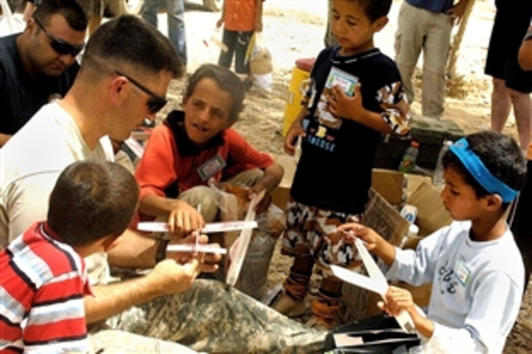 Iraqi children learn how to make a model airplane from a U.S Army soldier during a Youth Outreach Day on Contingency Operating Base Speicher, Tikrit, Iraq, July 12, 2008. The event was coordinated by the Provincial Reconstruction Team to increase understanding of coalition forces for children in the local community. 
