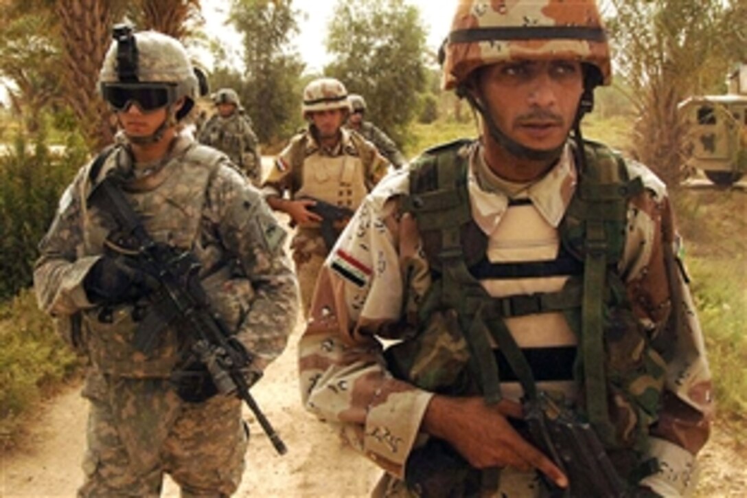 U.S. and Iraqi army soldiers walk to their next objective while searching for weapon caches in Abu Saymack, Iraq, July 08, 2008. The U.S. soldiers are assigned to the 101st Airborne Division's 1st Battalion, 33rd Cavalry Regiment.

