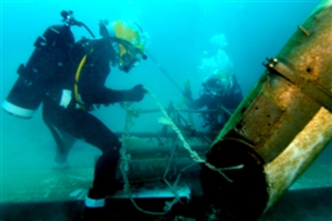 Divers secure wreckage to a shipboard crane off the shores of Pearl Harbor, Hawaii, during an international training exercise, Rim Of The Pacific 2008, July 17, 2008. 