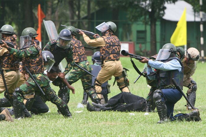 A riot control team comprised of Marines, sailors, Bangladesh service members and local law-enforcement personnel provide cover and apprehend members of a simulated mob July 22 during the Non-Lethal Weapons Executive Seminar 2008 Demonstration here.