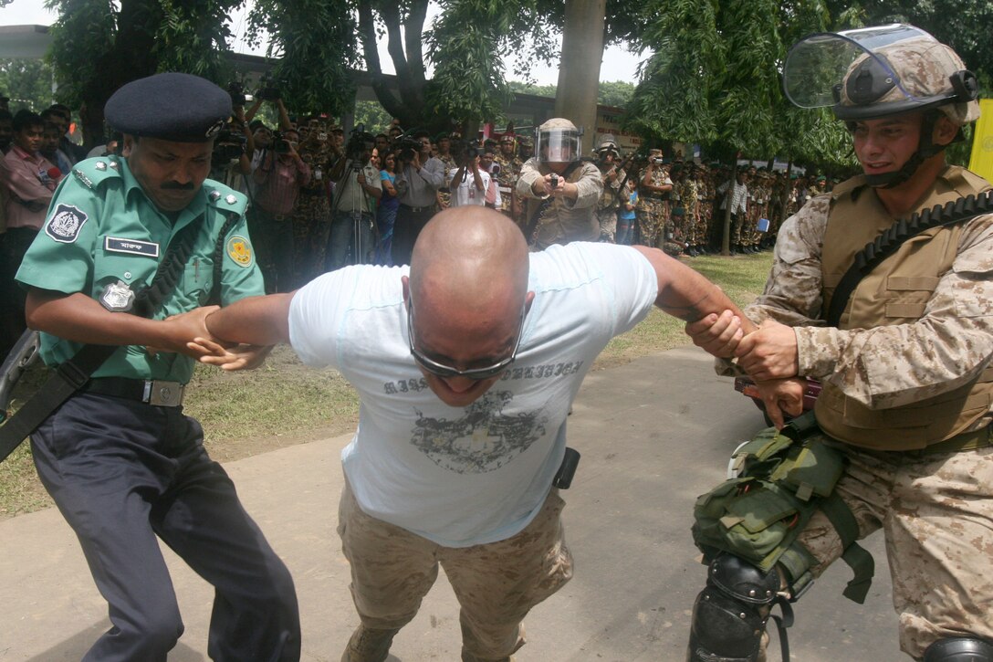 Sgt. Russel A. Douthat tasers Lance Cpl. Jesus Colone, a simulated aggressor, July 22 during the Non-Lethal Weapons Executive Seminar 2008 demonstration here. Douthat is an anti-terrorism force protection instructor with III Marine Expeditionary Force's Special Operations Training Group. Colone is an armorer with III MEF Headquarters Group.