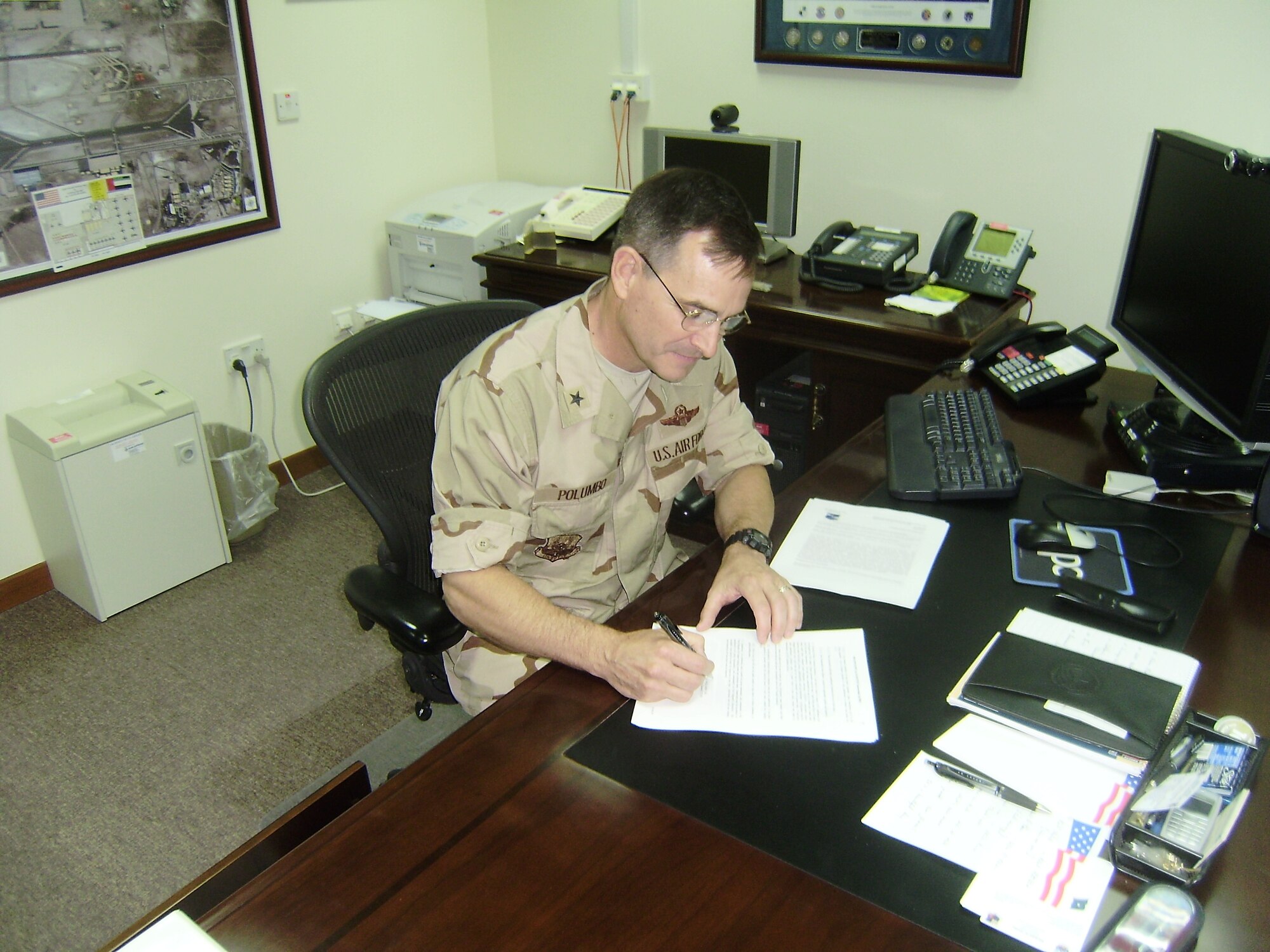 SOUTHWEST ASIA--Brig. Gen. Harry D. Polumbo, Jr., 380th Air Expeditionary Wing Commander, signs his approval for the updated Community Standards here. The Community Standards were developed as a way to communicate to all 380th AEW Airmen the expectations of dress, personal appearance, and adherance to privileges.