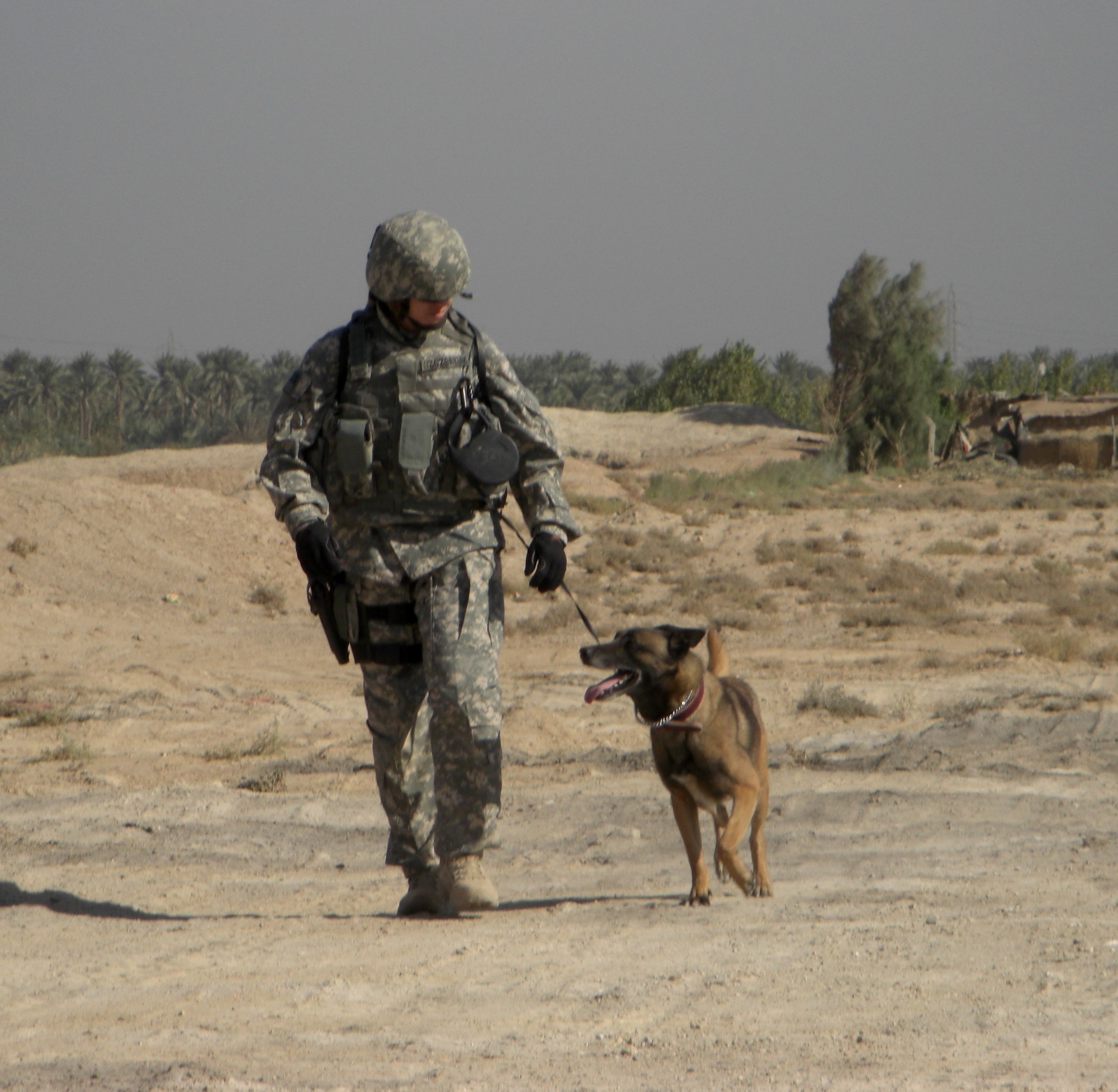 Staff Sgt. Melissa Szczerbiak, 62nd Security Forces Squadron, and her Belgian Malinois, Tim, patrol Camp Stryker, Iraq, during a recent deployment. (Courtesy photo)