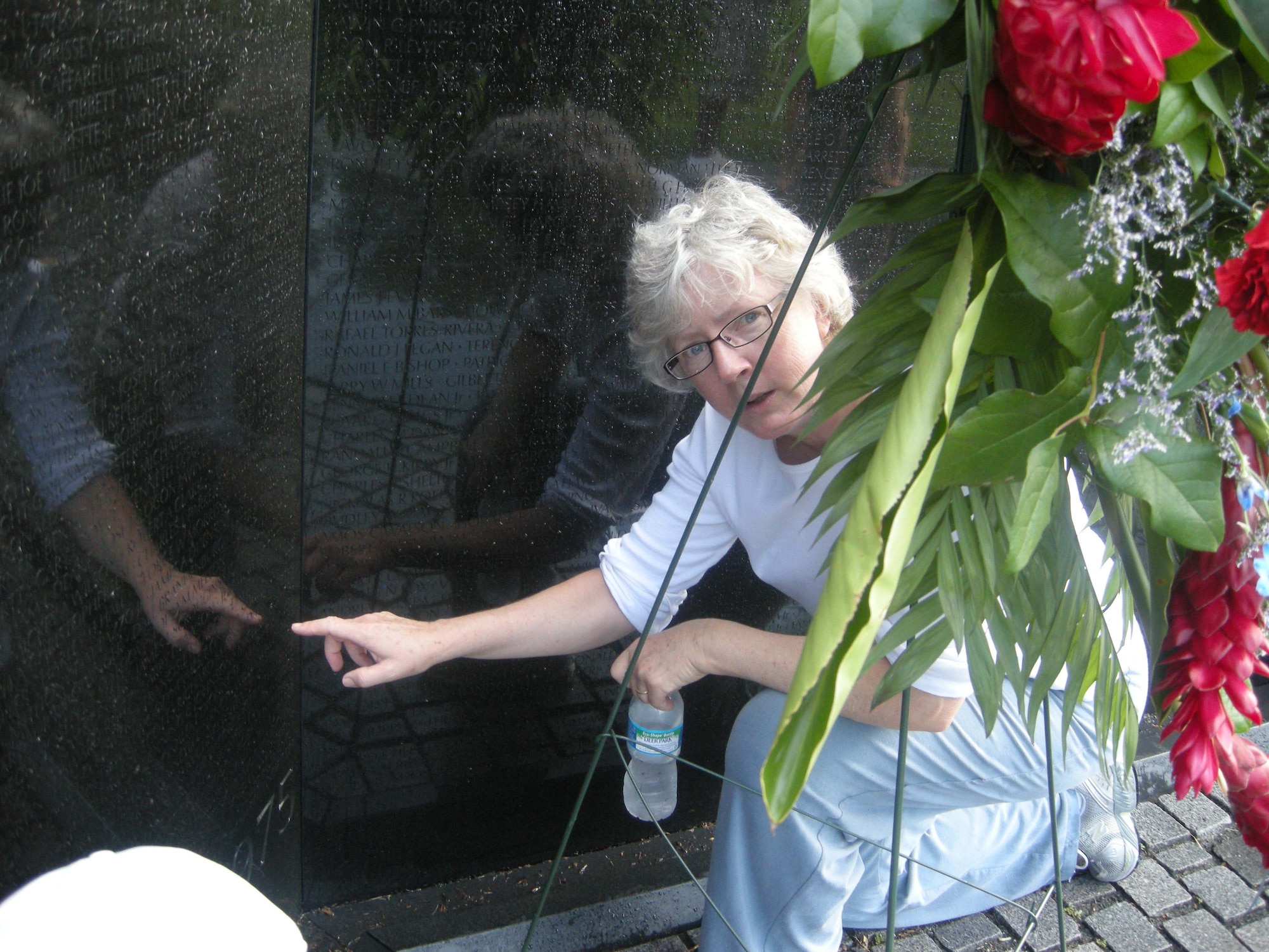 WASHINGTON --  Vietnam Memorial Wall washing volunteer Lt. Col. Margaret Schmidt, 459th Aeromedical Evacuation Squadron flight nurse, points to the etched name of 27-year-old Air Force Reservist Capt. Mary T. Kilnker, who became the last nurse and the only member of the Air Force Nurse Corps to be killed in Vietnam. The Operation Babylift volunteer's name is one of more than 58,000 fallen service members' etched into the nearly 247-foot granite wall. The wall washing is a way for service members to thank fallen service members and was conducted under the guidance of the National Park Service. The NPS coordinates volunteers to clean the wall each week, or 52 times per year.  At dawn, more than 20 members of the 459th Air Refueling Wing, family and other volunteers stood face to face with their own reflections while washing the names of memorialized service members. (U.S. Air Force photo/Tech. Sgt. Amaani Lyle)